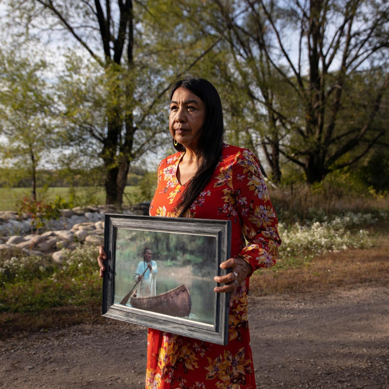 A woman holds a portrait of her late husband after he passed away due to a diabetes-related heart attack, in Red Wing, Minnesota, on September 29, 2021.