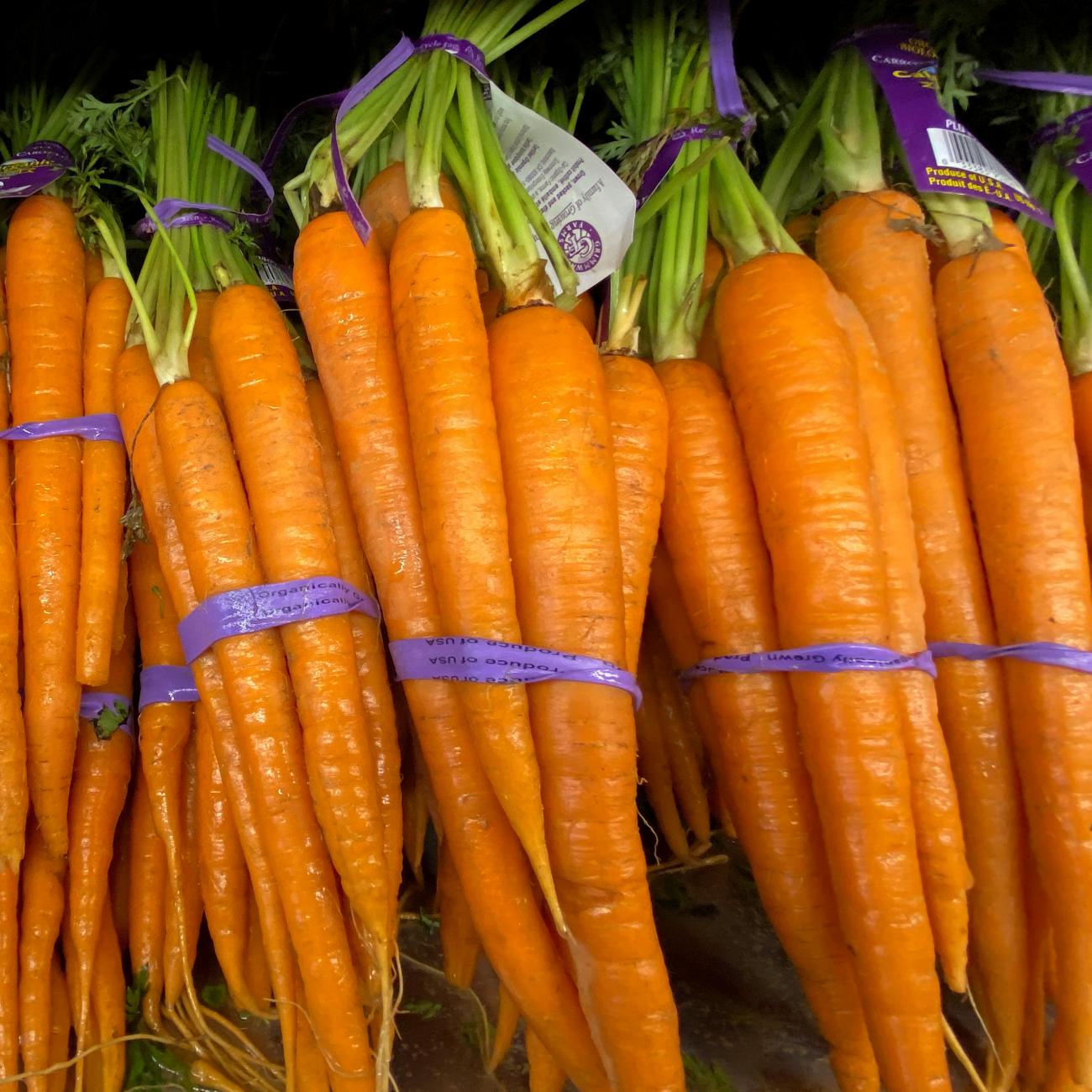 Fresh orange carrots lie in bunches side by side for sale at a grocery store in Del Mar, California, on June 3, 2020.