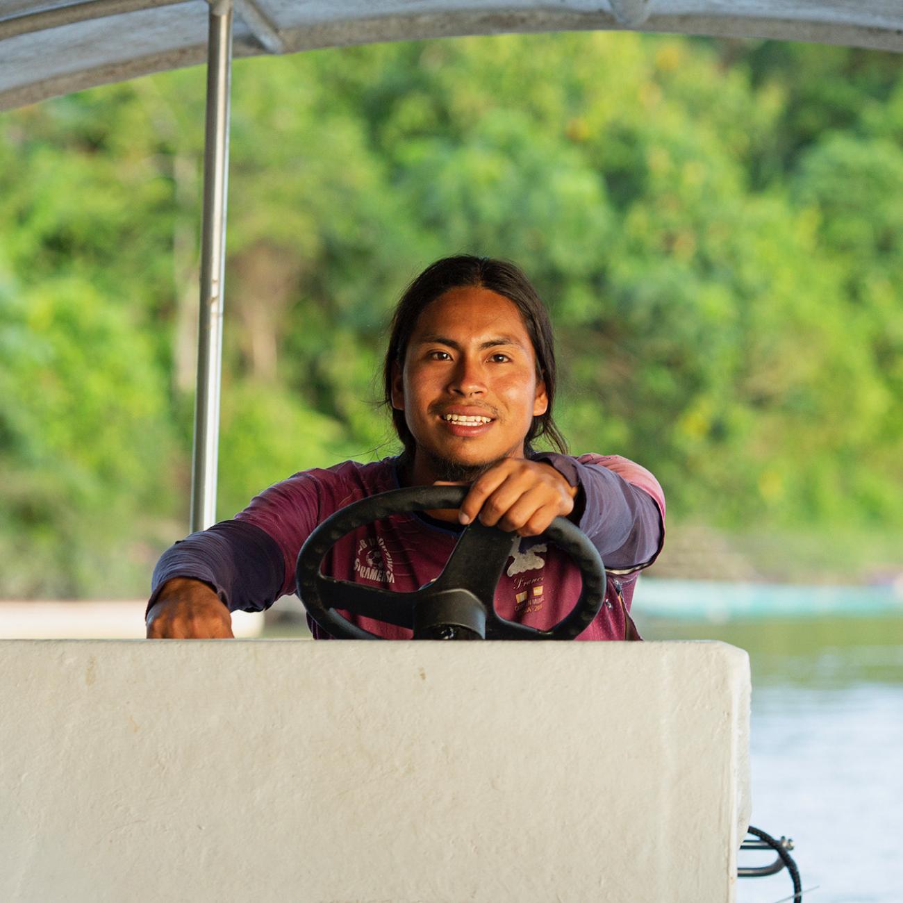 Luciano Peas, a member of the Achuar Indigenous community in Ecuador, captains a solar-powered boat.