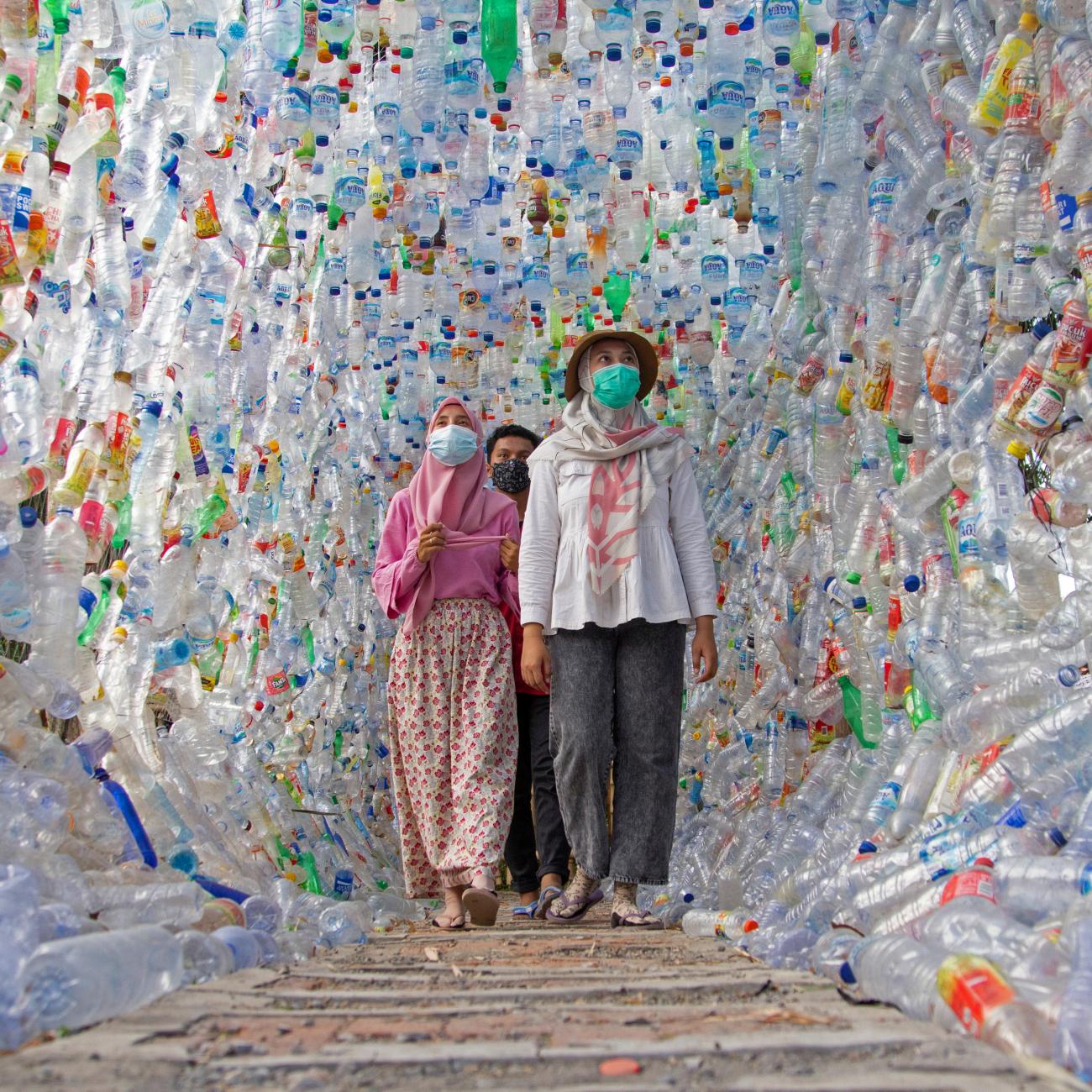 People walk through Terowongan 4444, built from plastic bottles collected from several rivers around the city in three years, constructed by an Indonesian environmental activist group.