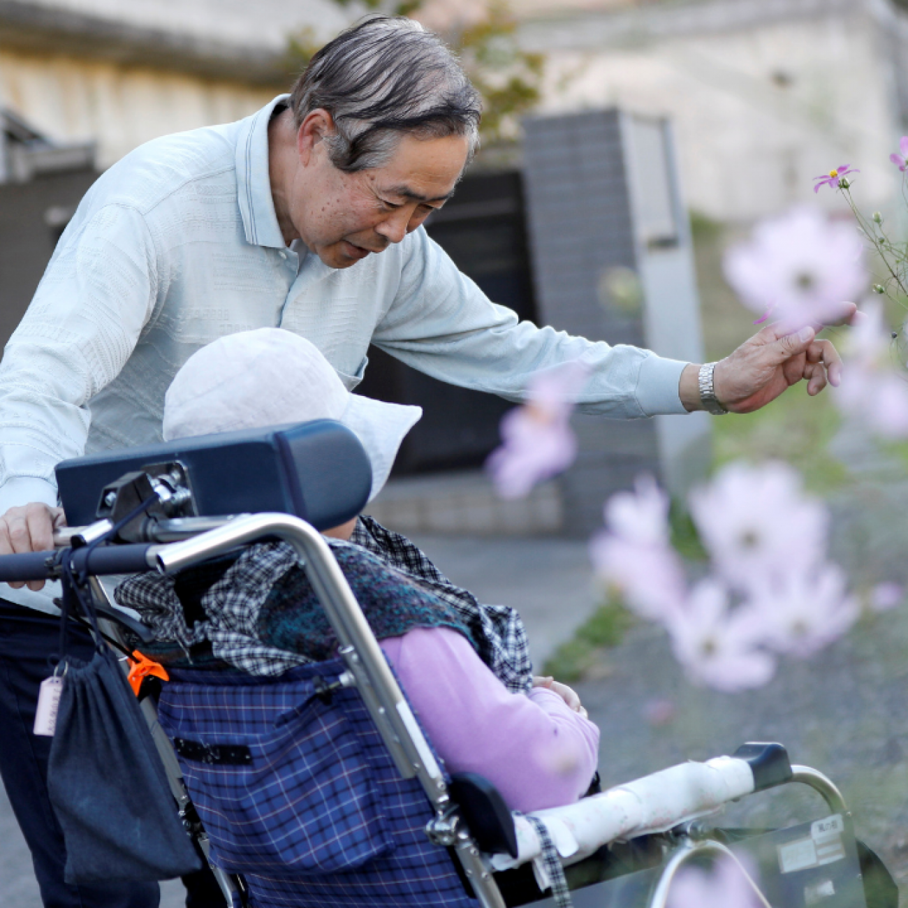 Eiichi Okubo, 71, speaks to his wife Yumiko, 68, who has been suffering from dementia, near her care house in Tokyo, Japan, on October 29, 2018.