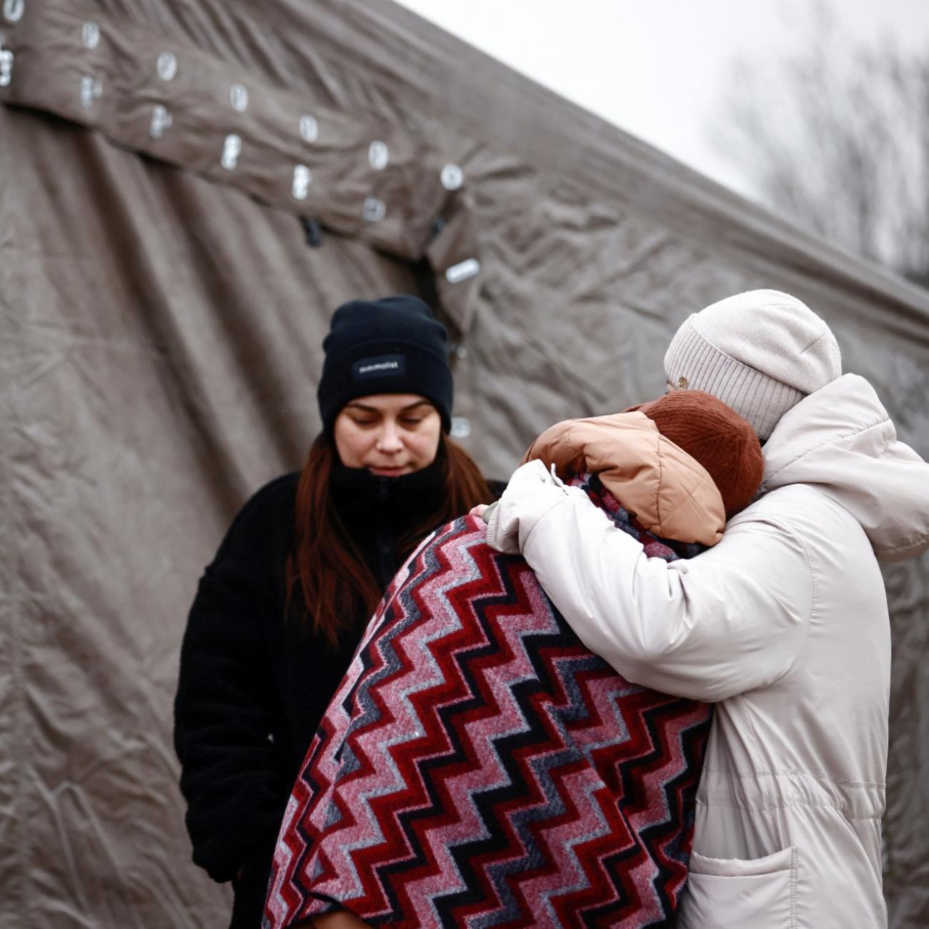 Women fleeing the Russian invasion of Ukraine, stay outside a tent at a temporary camp in Przemysl, Poland, March 2, 2022