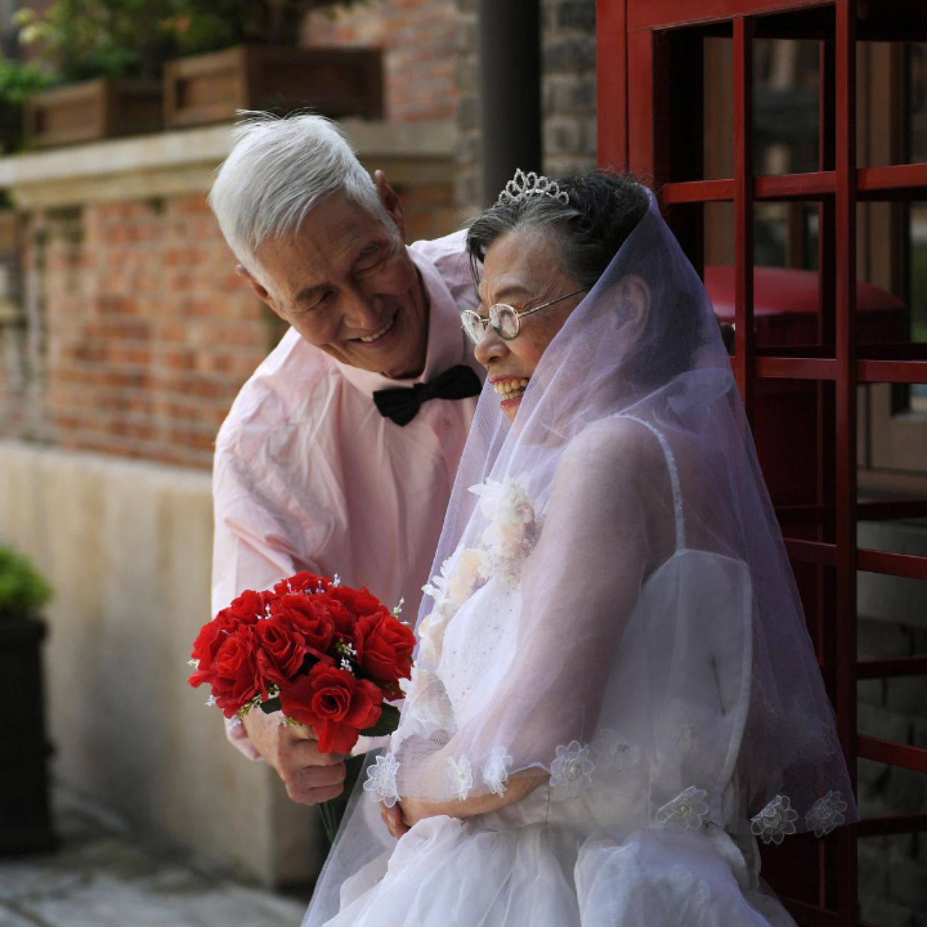 Chen Guozhi, 85, and his wife Chen Suzhen, 82, pose during a photo shoot to recreate wedding photos for elderly couples, who have been married for more than 50 years, Tianjin, China, August 16, 2018