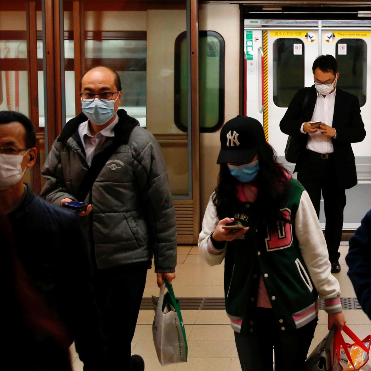 People wear protective masks following the outbreak of a new coronavirus, during their morning commute in a station, in Hong Kong, China