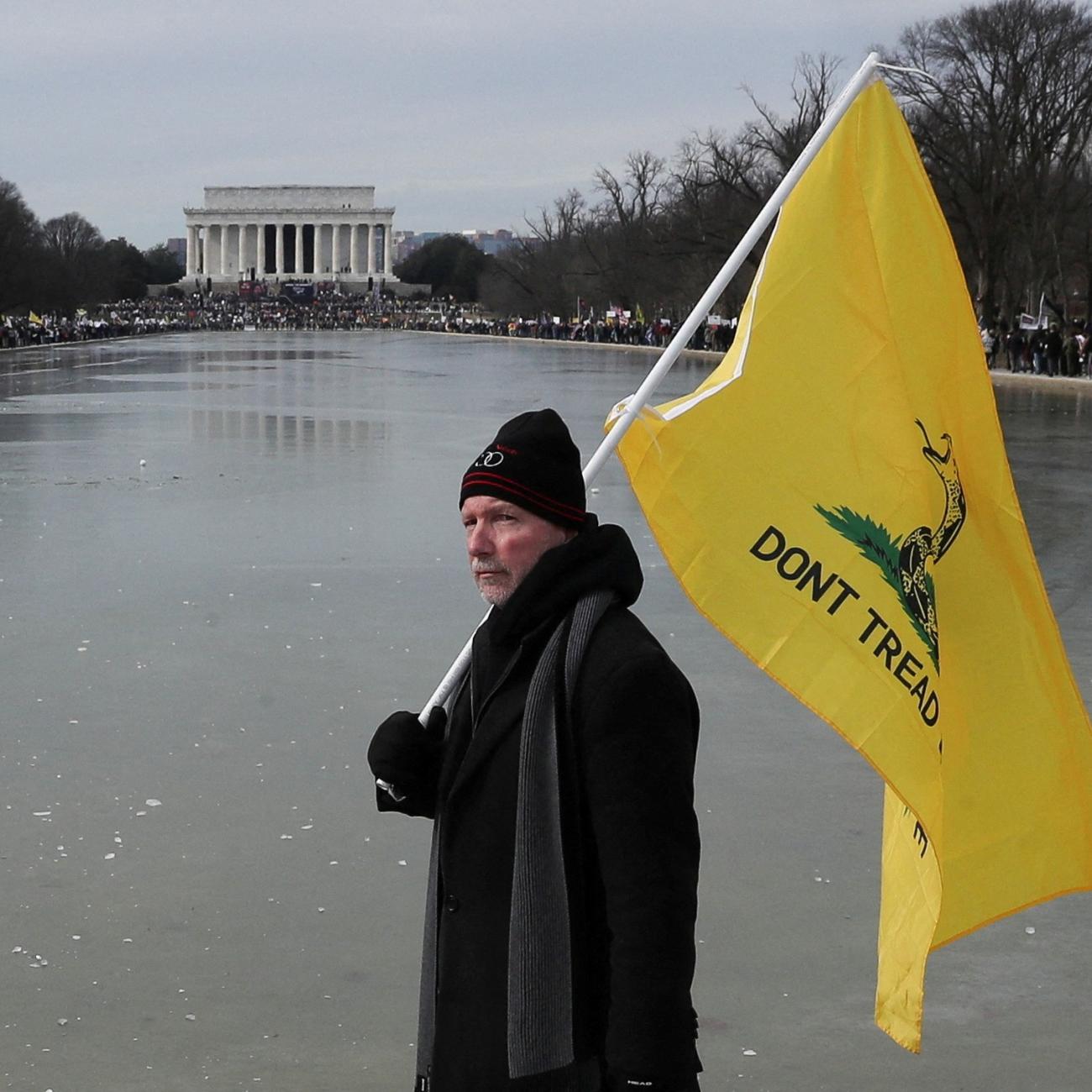 A man holds a flag during a march in opposition to coronavirus disease (COVID-19) mandates on the National Mall in Washington, D.C