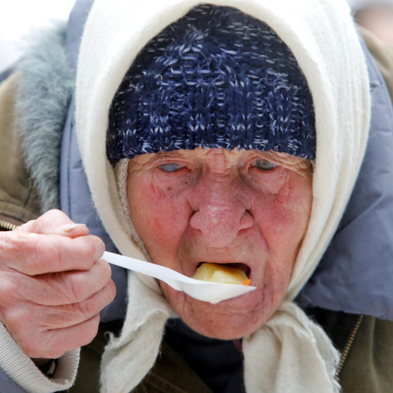 An elderly woman has a meal during a charity event to distribute food among lower-income citizens in a cathedral compound in Stavropol, Russia December 13, 2019