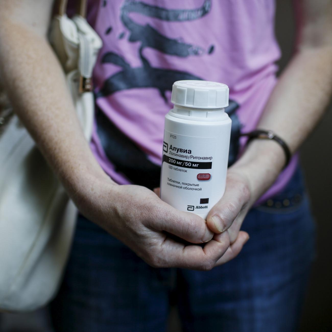 An activist of the All-Ukrainian Network of People Living With HIV/AIDS, a non-governmental group, holds an empty package of the drug Aluvia, as she takes part in a rally in front of the Ukrainian cabinet of ministers building in Kyiv, Ukraine, July 1, 2015. 