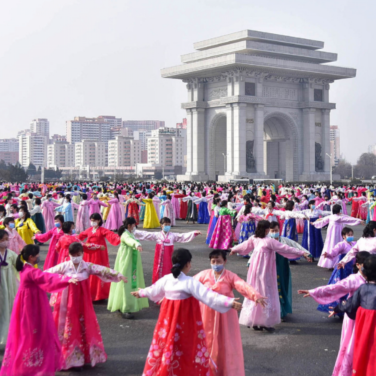 Hundreds of women dressed in pink and white traditional North Korean gowns stand in rows in a central area of Pyongyang, North Korea, on Women's Day in March 2022.