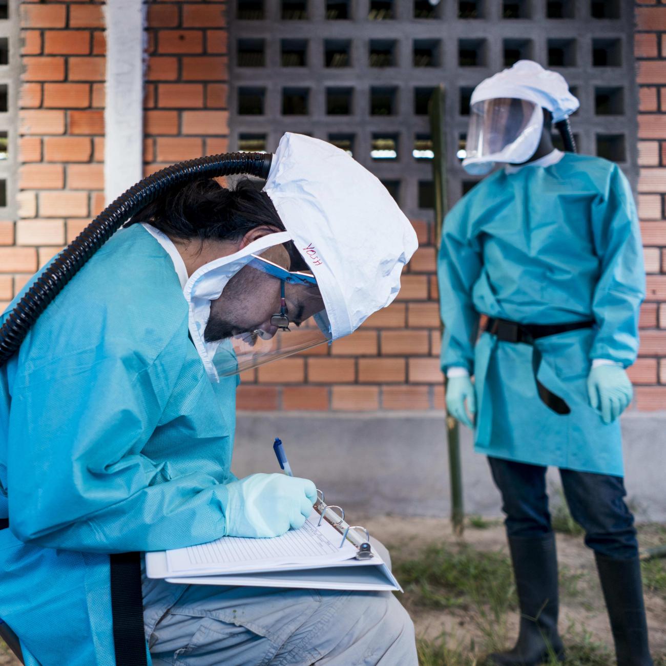 CDC biologists a and Congolese scientist wear blue surgical gowns and respirators, as they examine animals caught in the jungle who may carry the MonkeyPox virus, in Manfuette, Republic of Congo on August 29, 2017