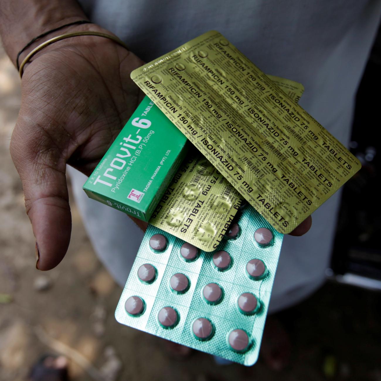 A tuberculosis patient holds his medicines received from the government's tuberculosis center in Rawalpindi, Pakistan July 11, 2016. The pink pills are sealed in rows of green packaging with gold foil on the back that gives the name and dosage of the drug.