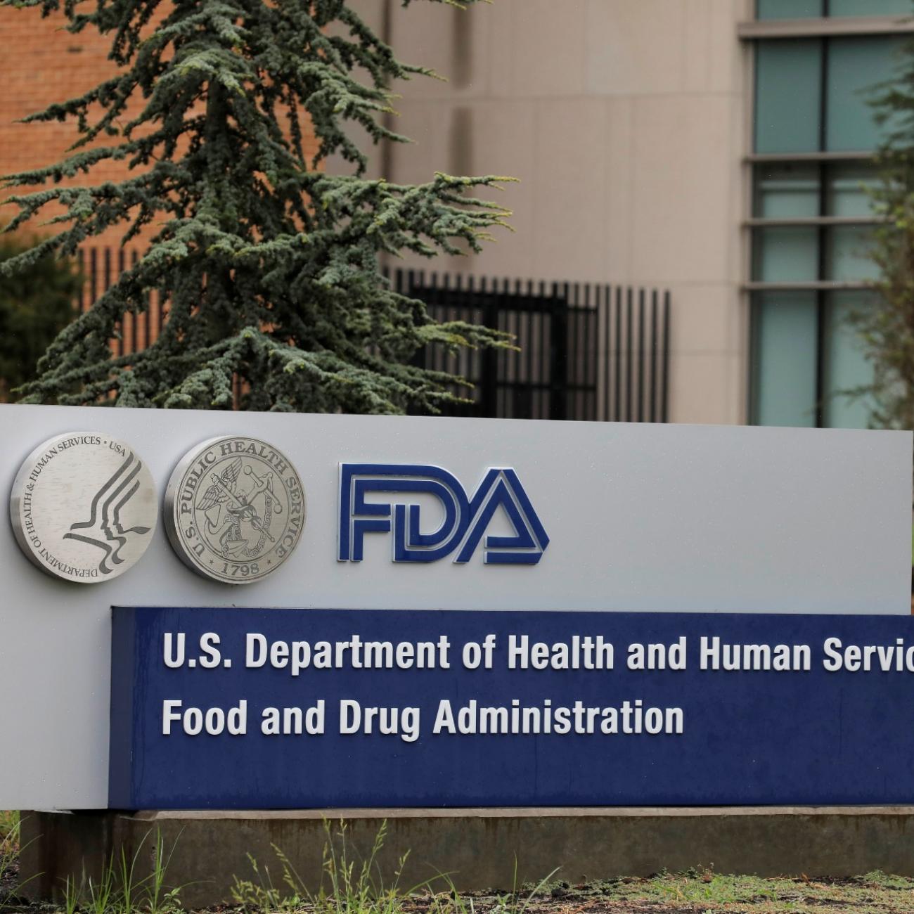 A blue and silver sign that reads "FDA: U.S. Department of Health and Human Services Food and Drug Administration" is seen in the lawn outside the FDA building in Maryland