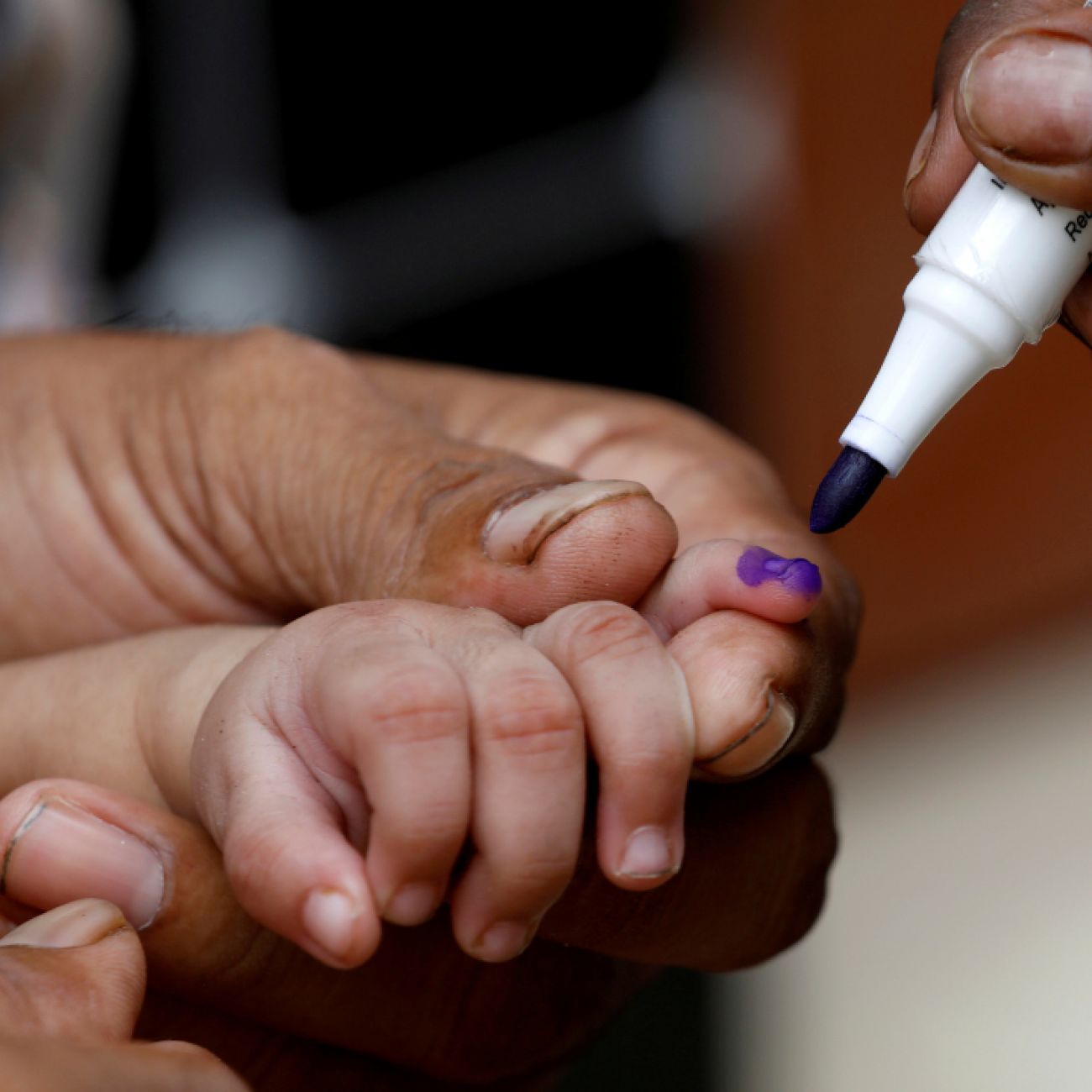 A close-up image of a child's hand being marked with a purple pen after he is administered polio vaccine drops, during an anti-polio campaign in Karachi, Pakistan, on July 20, 2020. 