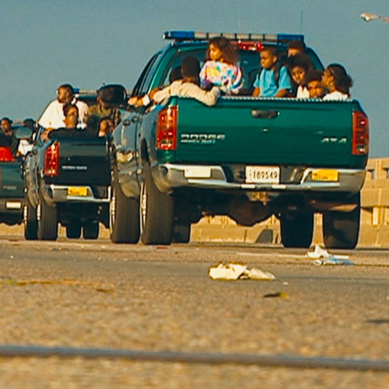 A caravan of green trucks carry child evacuees displaced during Hurricane Katrina