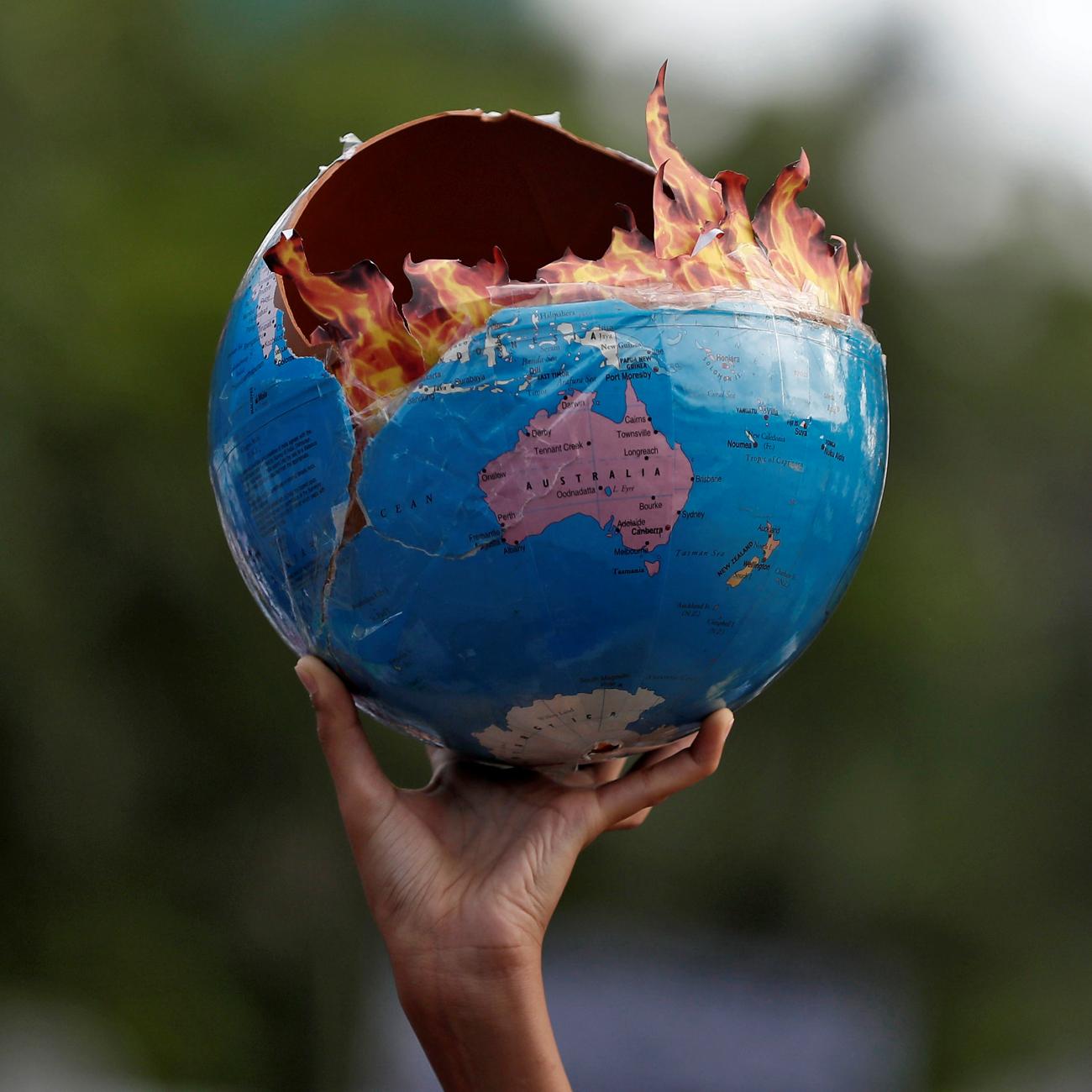 A protestor participating in a "Fridays for Future" march calling for urgent measures to combat climate change holds a globe designed to look like it is on fire, in Mumbai, India, on September 27, 2019. 