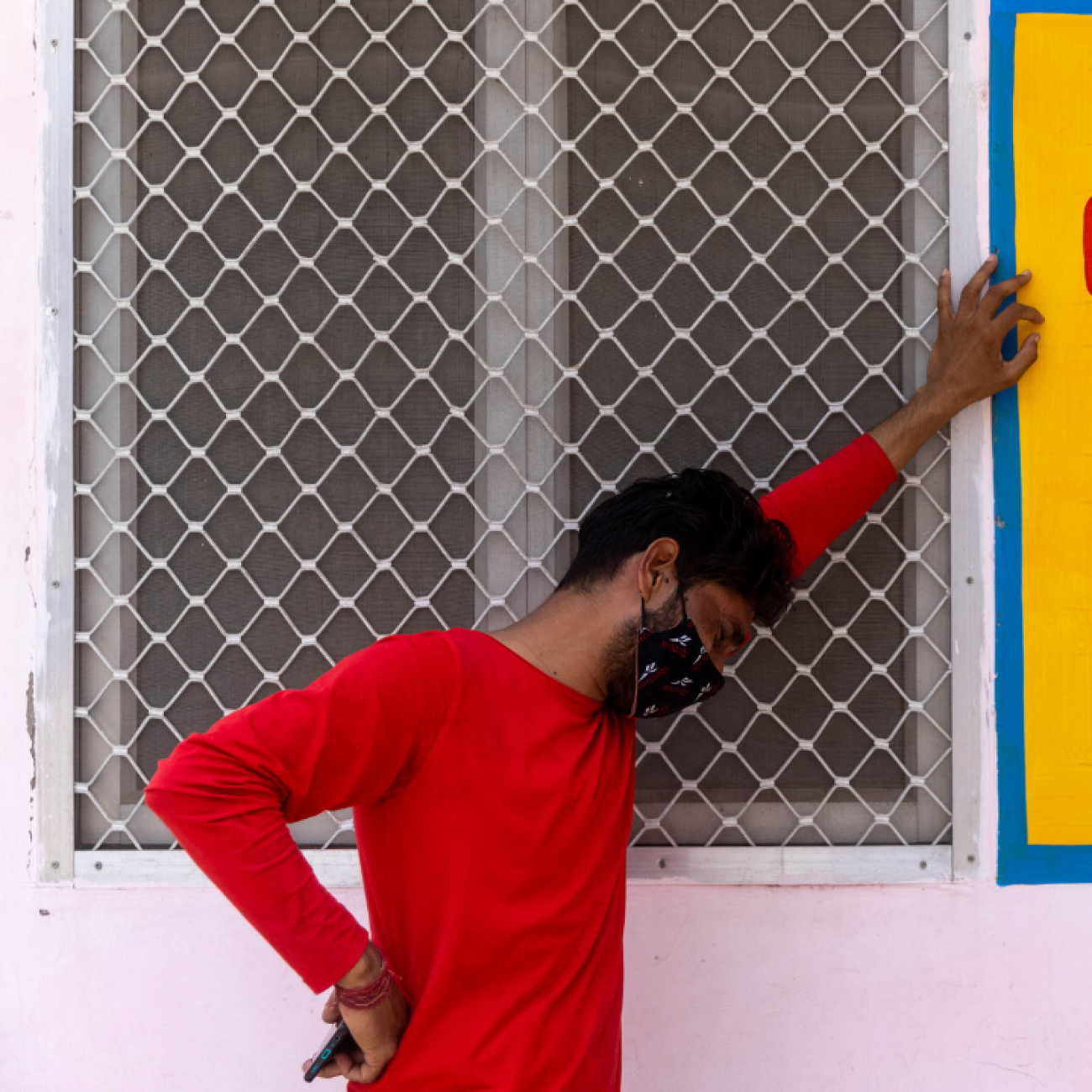 A man in a red shirt stands in profile and weeps as his mother is being treated inside a COVID-19 intensive care unit of a government-run hospital, amidst the coronavirus pandemic, in Bijnor District, Uttar Pradesh, India, on May 11, 2021. Photo by REUTERS/Danish Siddiqui