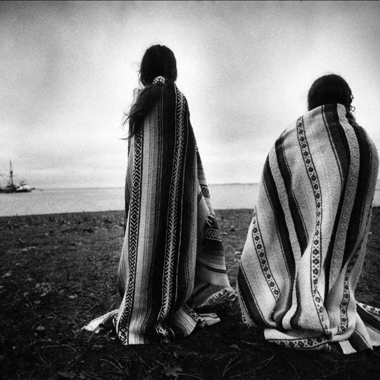 Weetoomoo Carey, 8, left, and her sister Jackolynn Carey, 5, Wampanoag Nipmucs from Mashpee, look across to the Mayflower replica anchored near Plymouth Rock in Plymouth, Mass. on Nov. 26, 1991. 