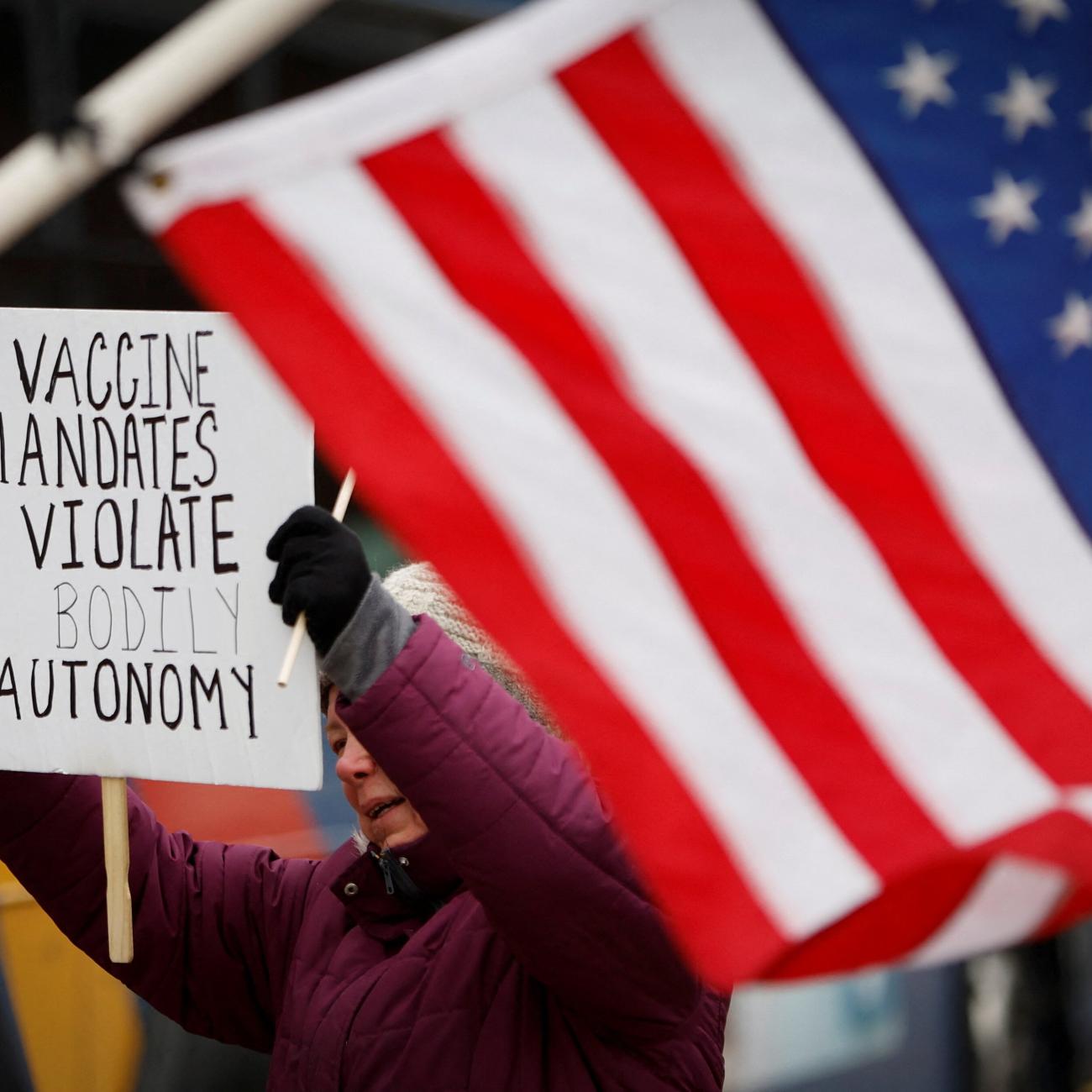 A protester holds a banner at a rally against mandates for the vaccines against the coronavirus disease (COVID-19) outside the New York State Capitol in Albany, New York.
