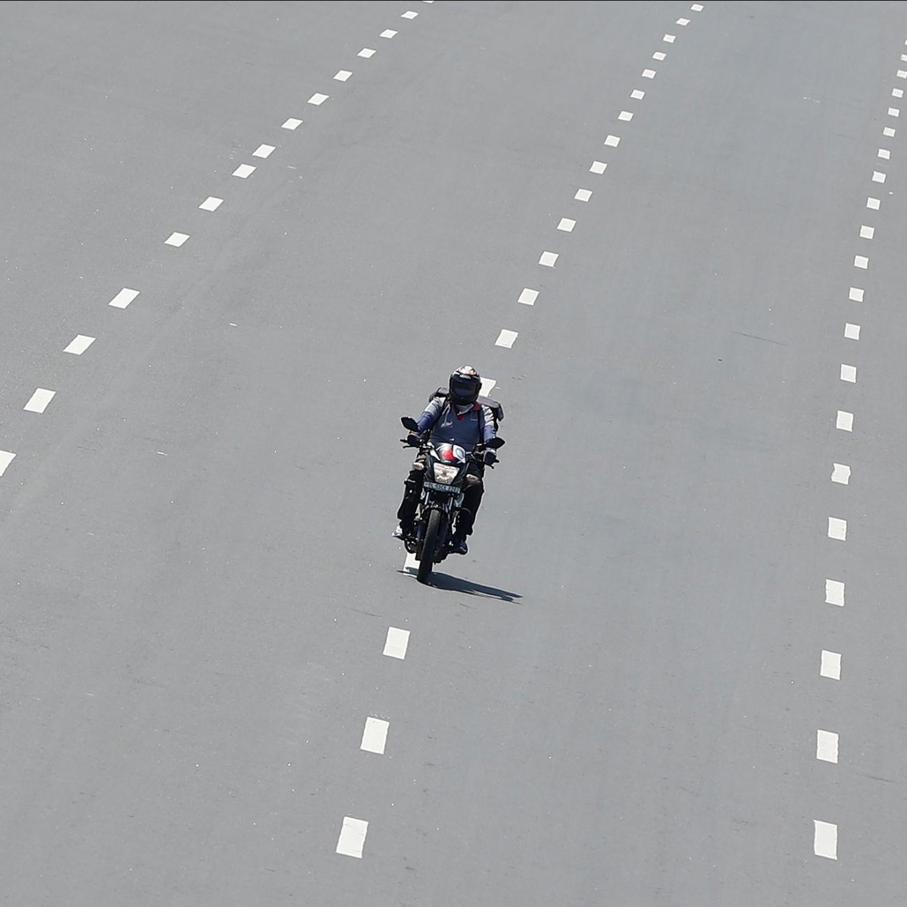 Delivery worker Devender Singh, who works for Licious, an online meat store, rides his bike on a deserted road, in New Delhi, India, on April 6, 2020.