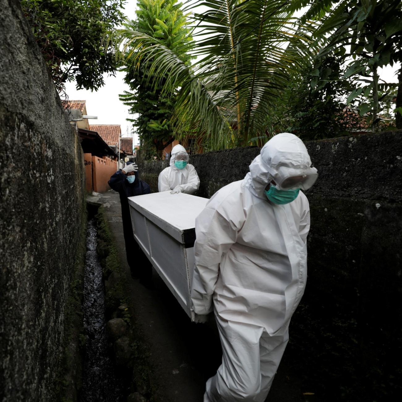 Volunteer undertakers help carry the coffin of 64-year-old Yoyoh Sa'diah who passed away due to complications related to COVID-19, at home in Bogor, West Java province, Indonesia, on July 8, 2021.