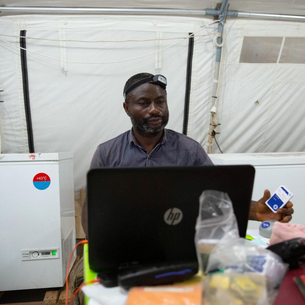 Benjamin Makele, logistician responsible for the cold chain with Doctors Without Borders (MSF), prepares to plug a vaccine temperature log into his computer in Boso-Manzi in Mongala province in the Democratic Republic of Congo February 27, 2020.