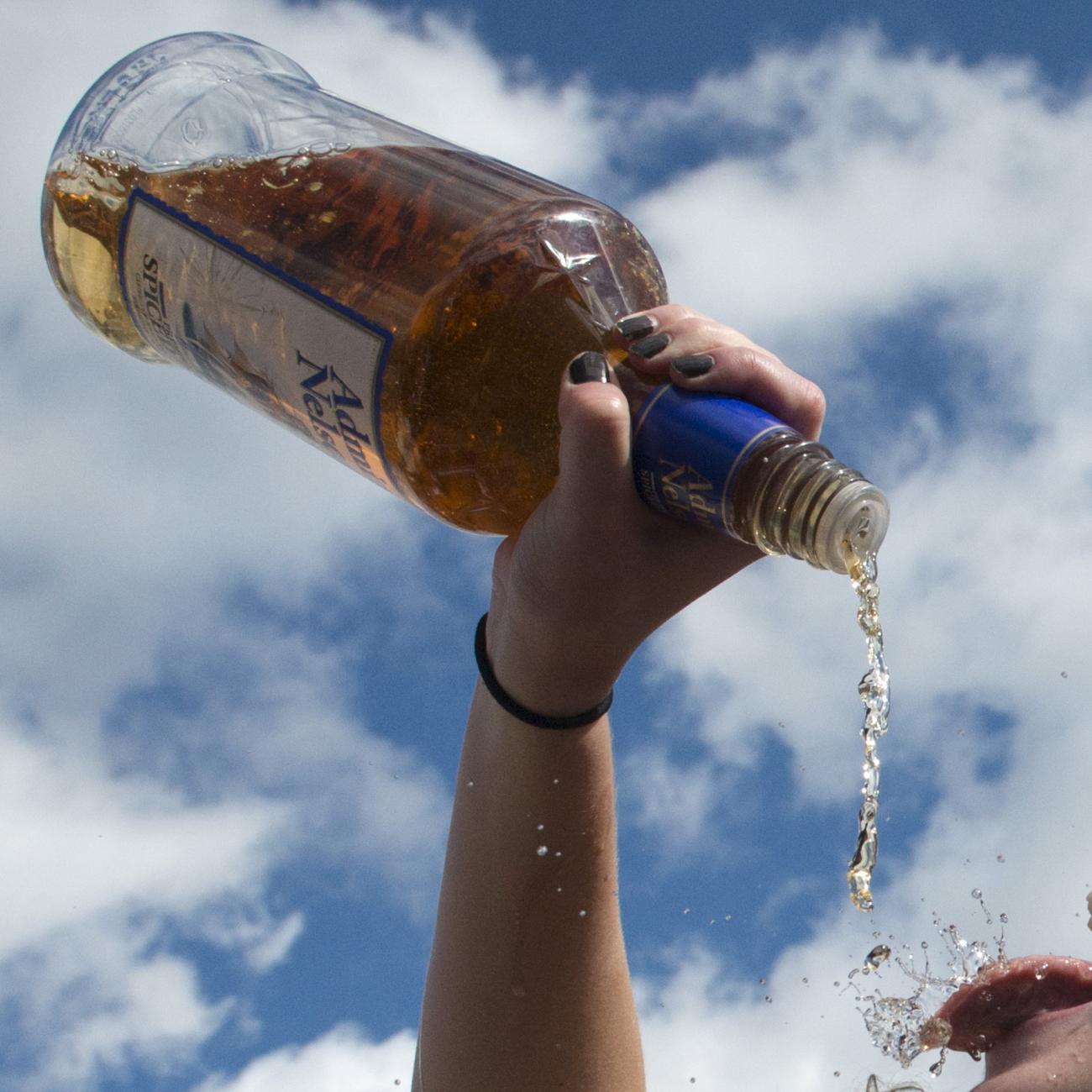 A woman pours alcohol from the bottle into her mouth at the Far Hills Race Day at Moorland Farms in Far Hills, New Jersey, on October 17, 2015. 