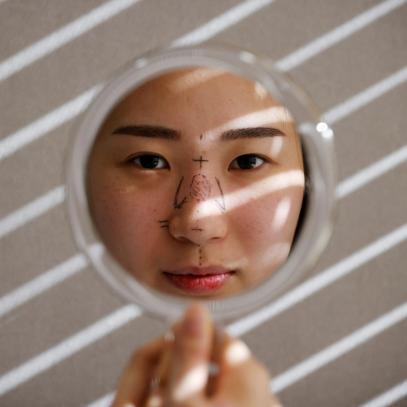 Ryu Han-na poses for photographs before undergoing nose plastic surgery at WooAhIn Plastic Surgery Clinic in Seoul, South Korea, December 17, 2020.