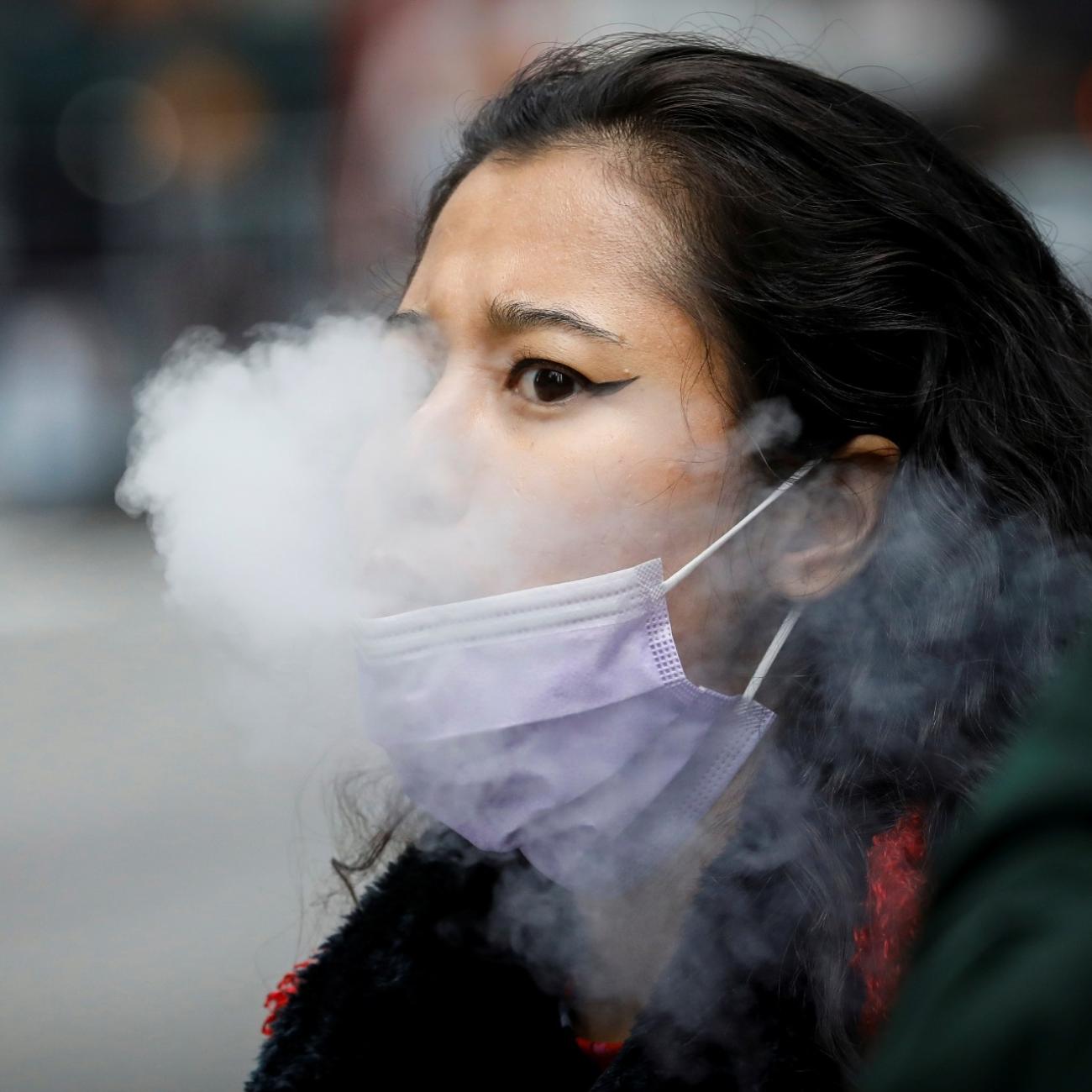 A woman exhales after vaping in Times Square, during the COVID-19 outbreak, in New York City, on March 31, 2020.