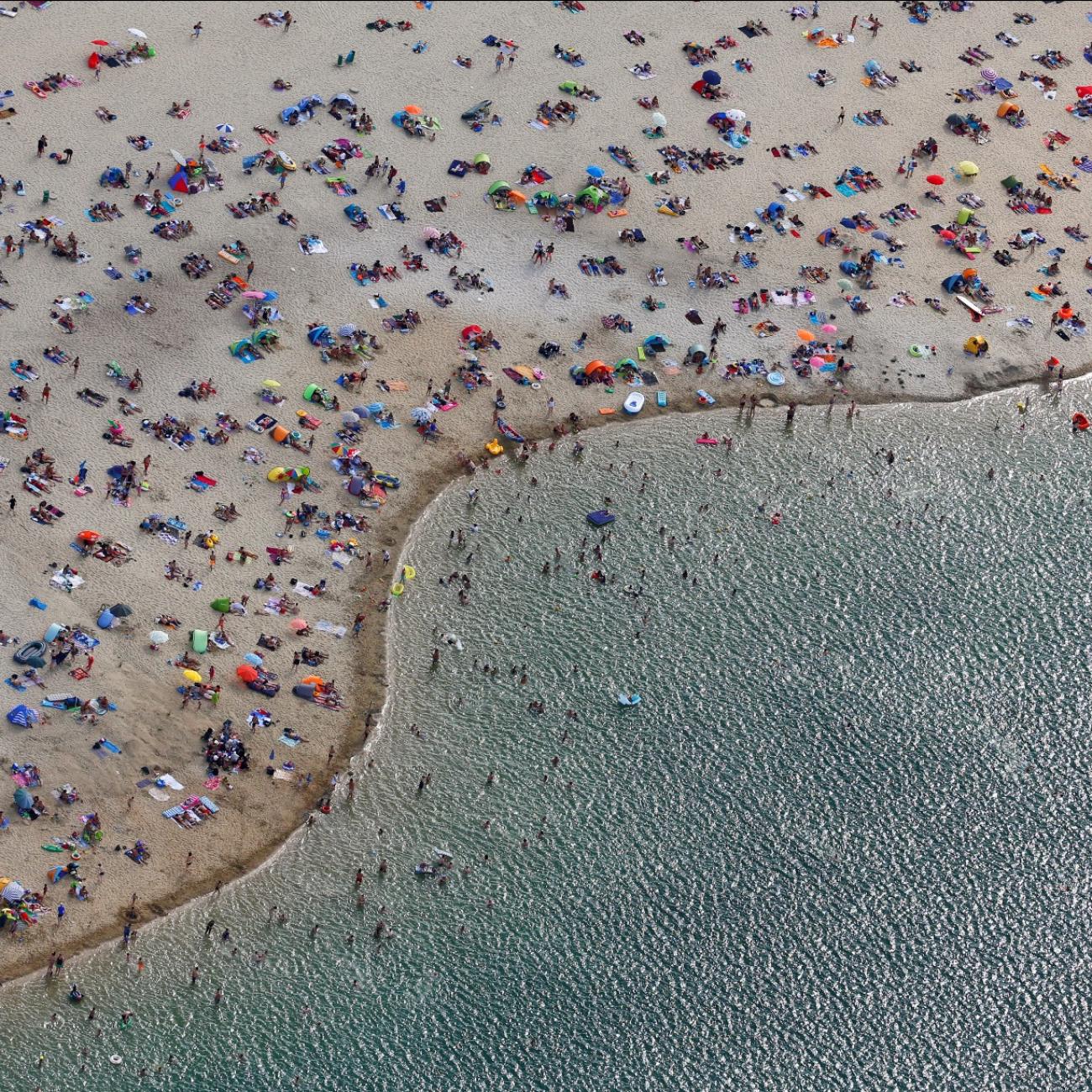 an arial view shows people at the beach on the shores of lake Silbersee
