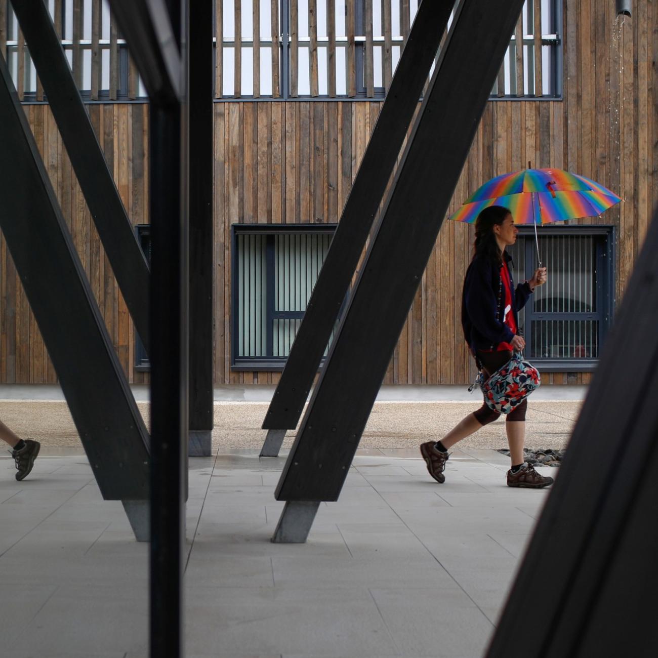 Alzheimer's patient Laetitia, 39, is reflected in a mirror as she walks with an umbrella at the Village Landais Alzheimer site in Dax, France, September 24, 2020. Picture taken on September 24, 2020.