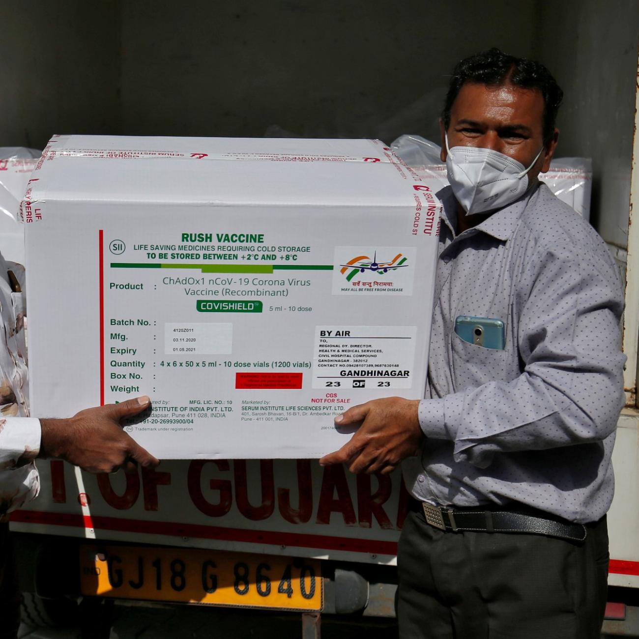 workers unload a box of covid vaccines