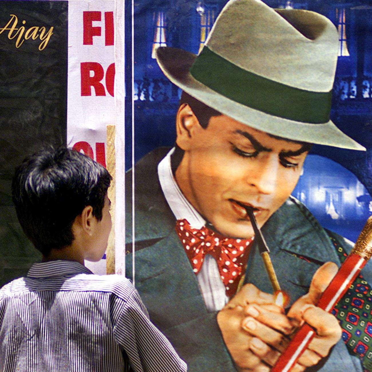 A boy looks at a posters of Bollywood stars smoking cigarettes during An anti-tobacco demonstration in Bombay, India.