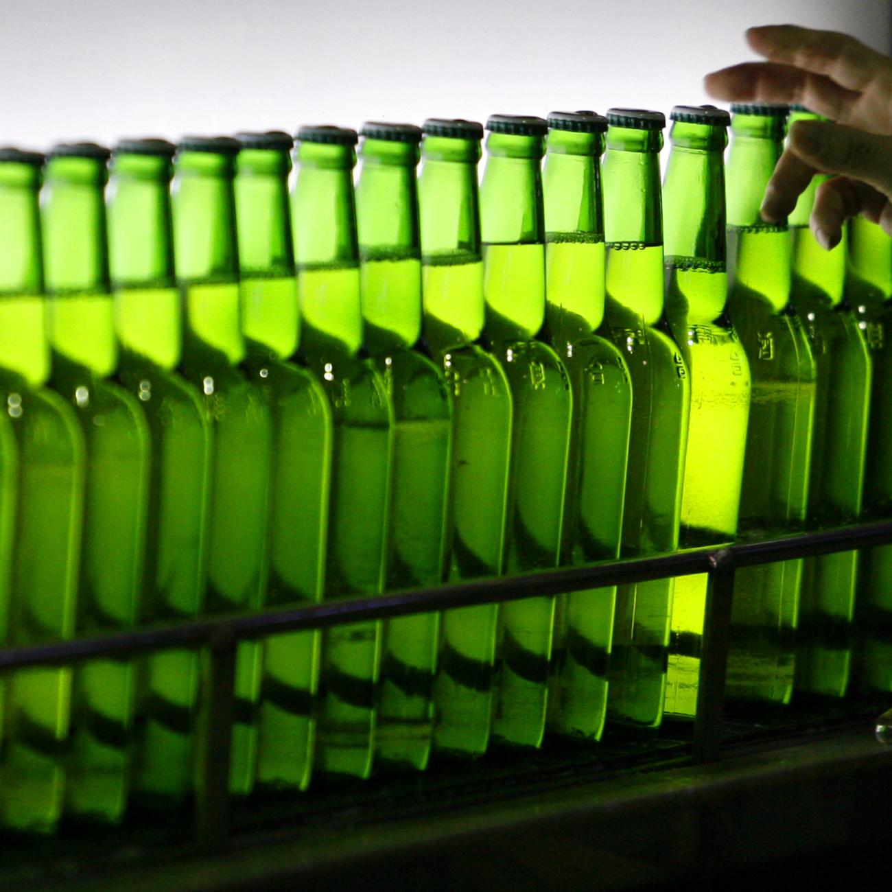 A man picks a green bottle at an assembly line inside the Taiwan Beer factory in Jhunan, Miaoli County, Taiwan, February 13, 2008.