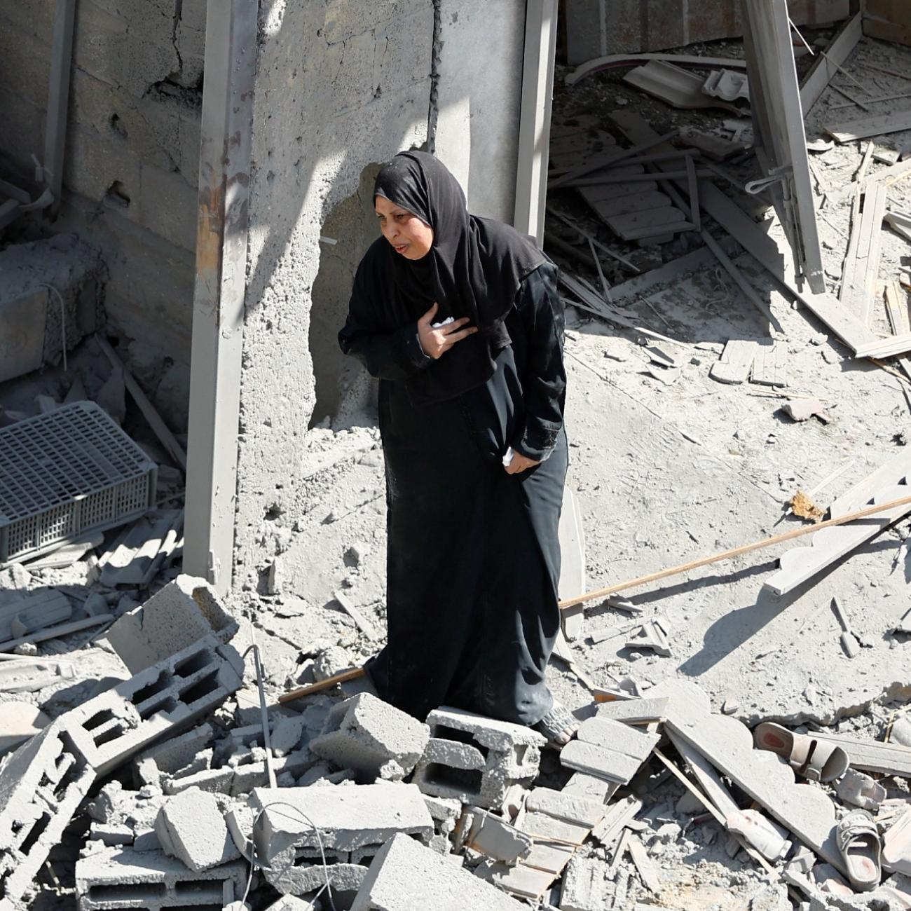 A Palestinian woman reacts at the site of Israeli strikes on houses, in Rafah in the southern Gaza Strip, on October 17, 2023