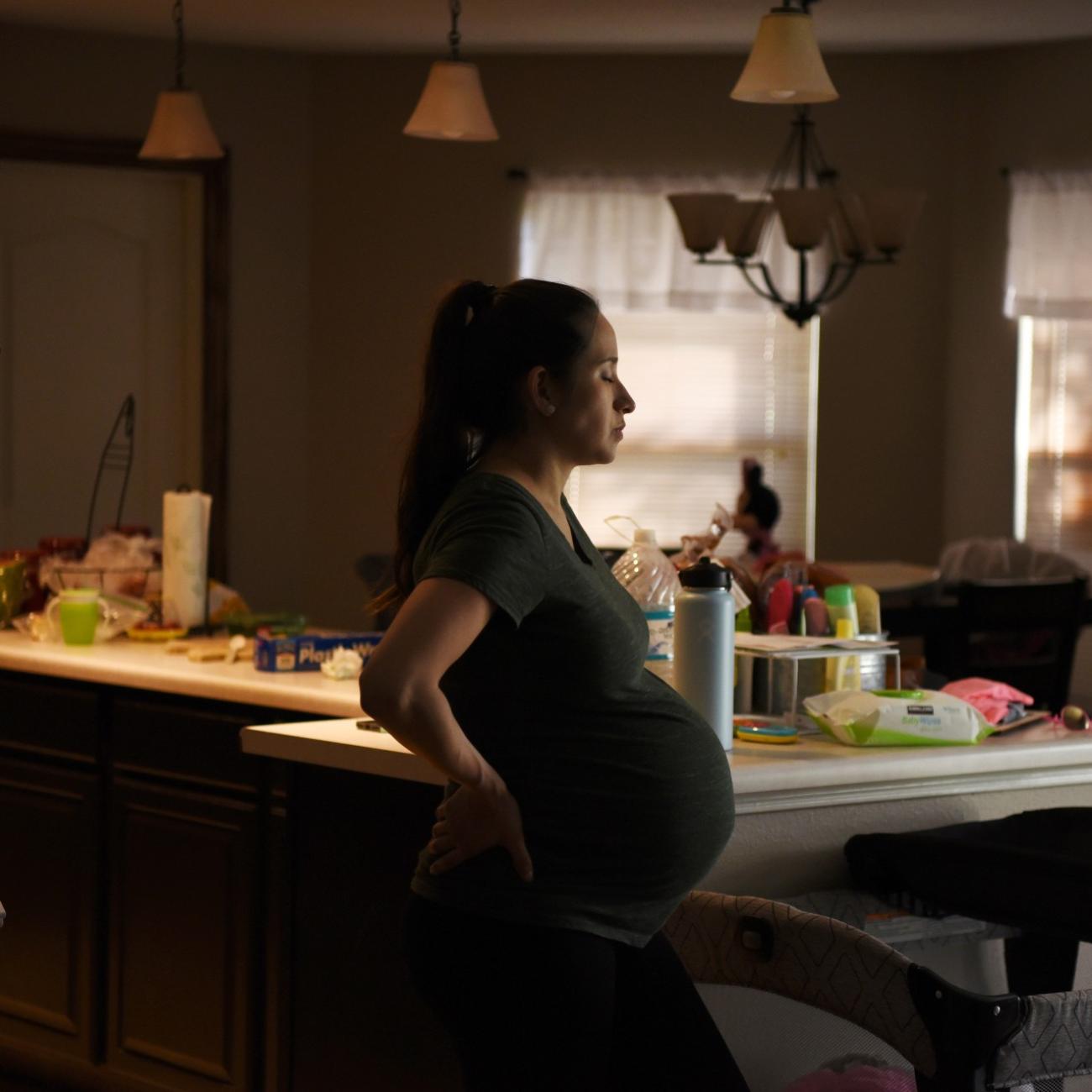 Pregnant woman stands in her kitchen in San Antonio, Texas, on May 6, 2020.