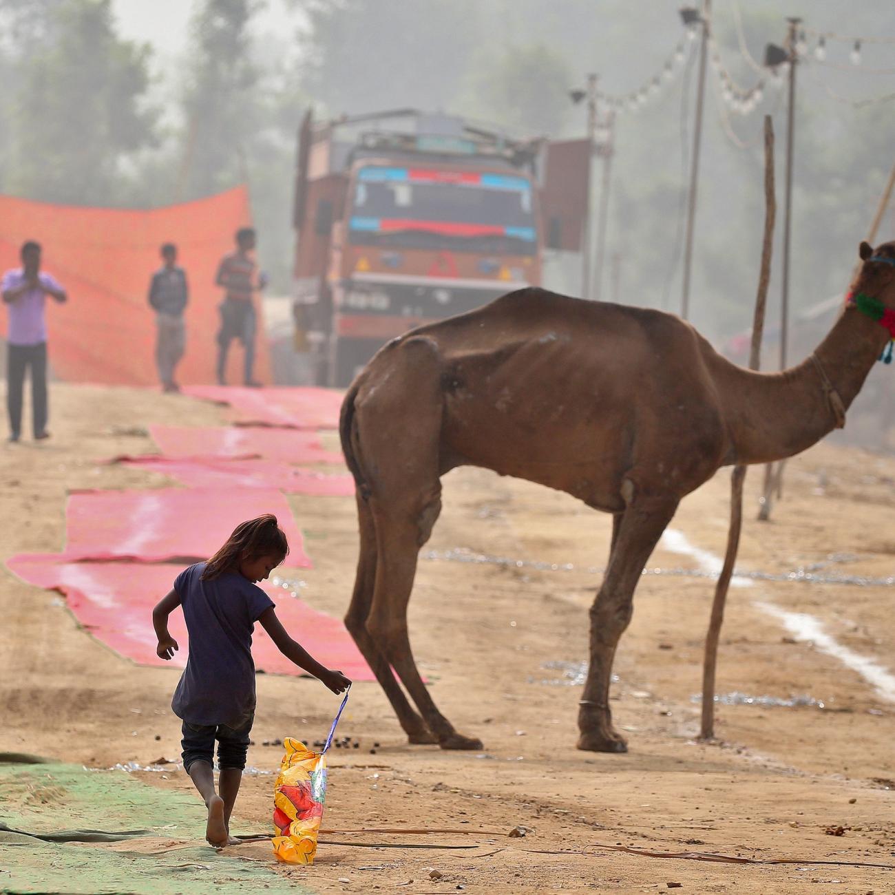 A girl plays with a deflated balloon as she walks through smog in Delhi, India November 7, 2016.