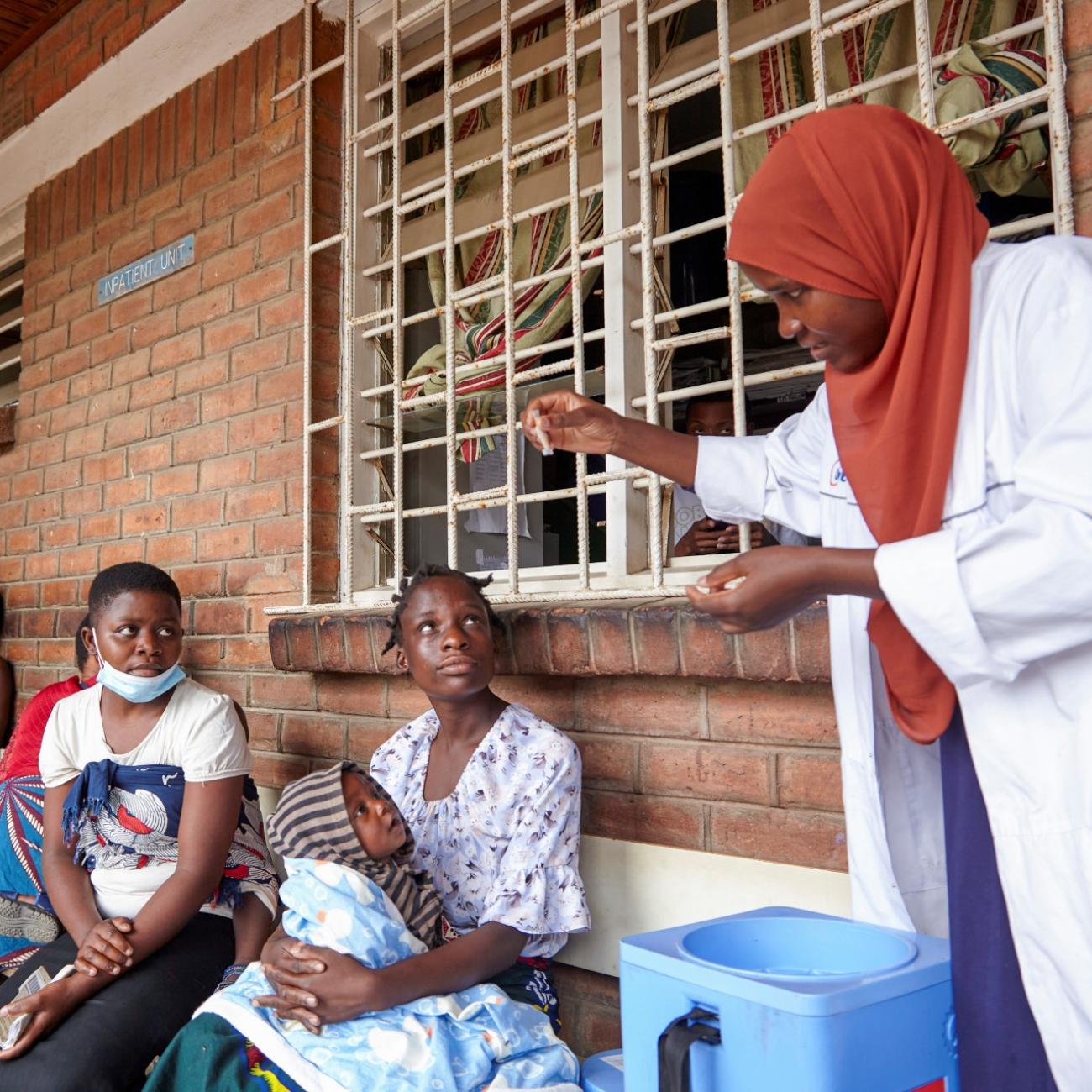 A clinician at Ndirande Health Centre demonstrates to clients how to take the cholera vaccine in response to the latest cholera outbreak.