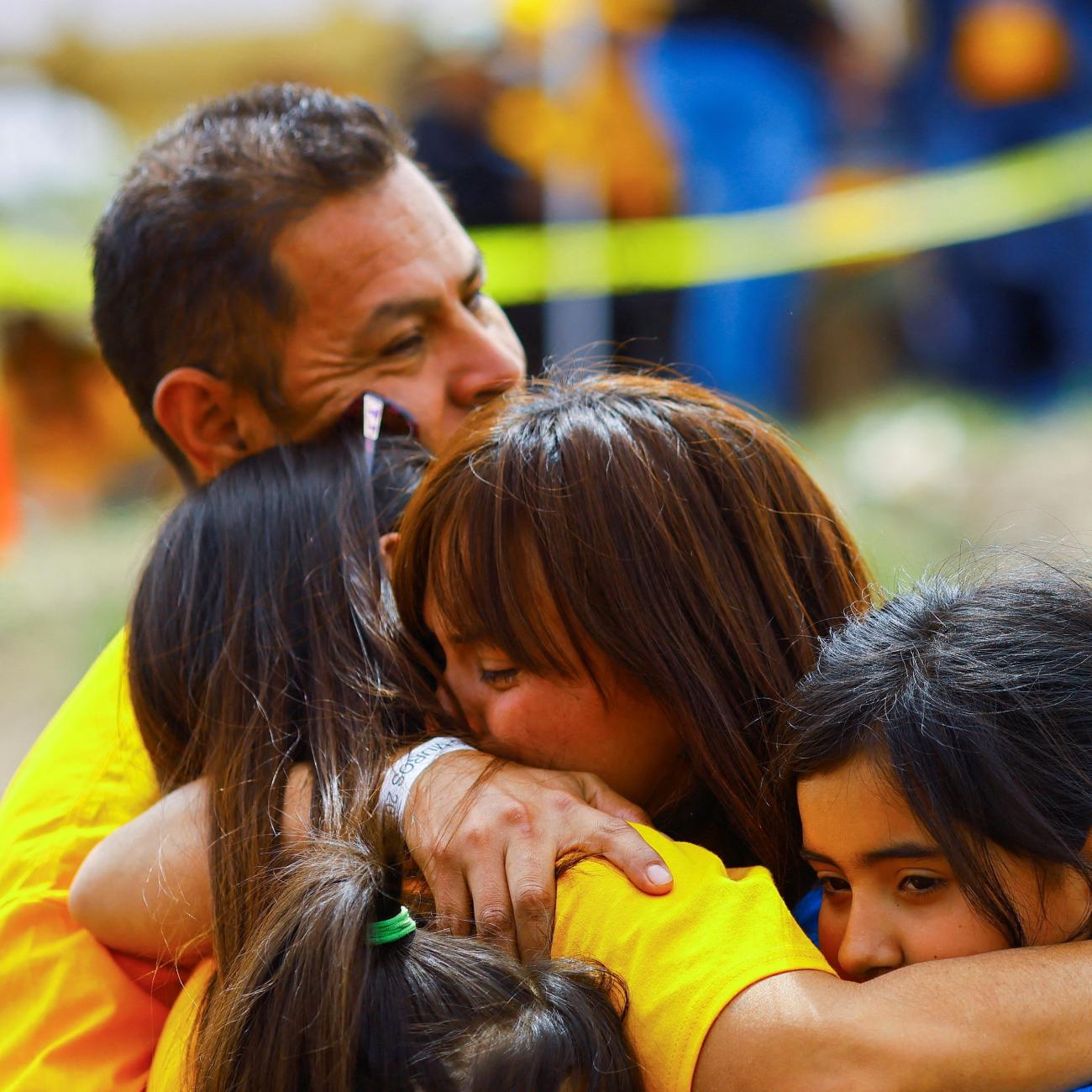 Families hug each other as they participate in a reunification meeting for relatives separated by deportation and immigration.