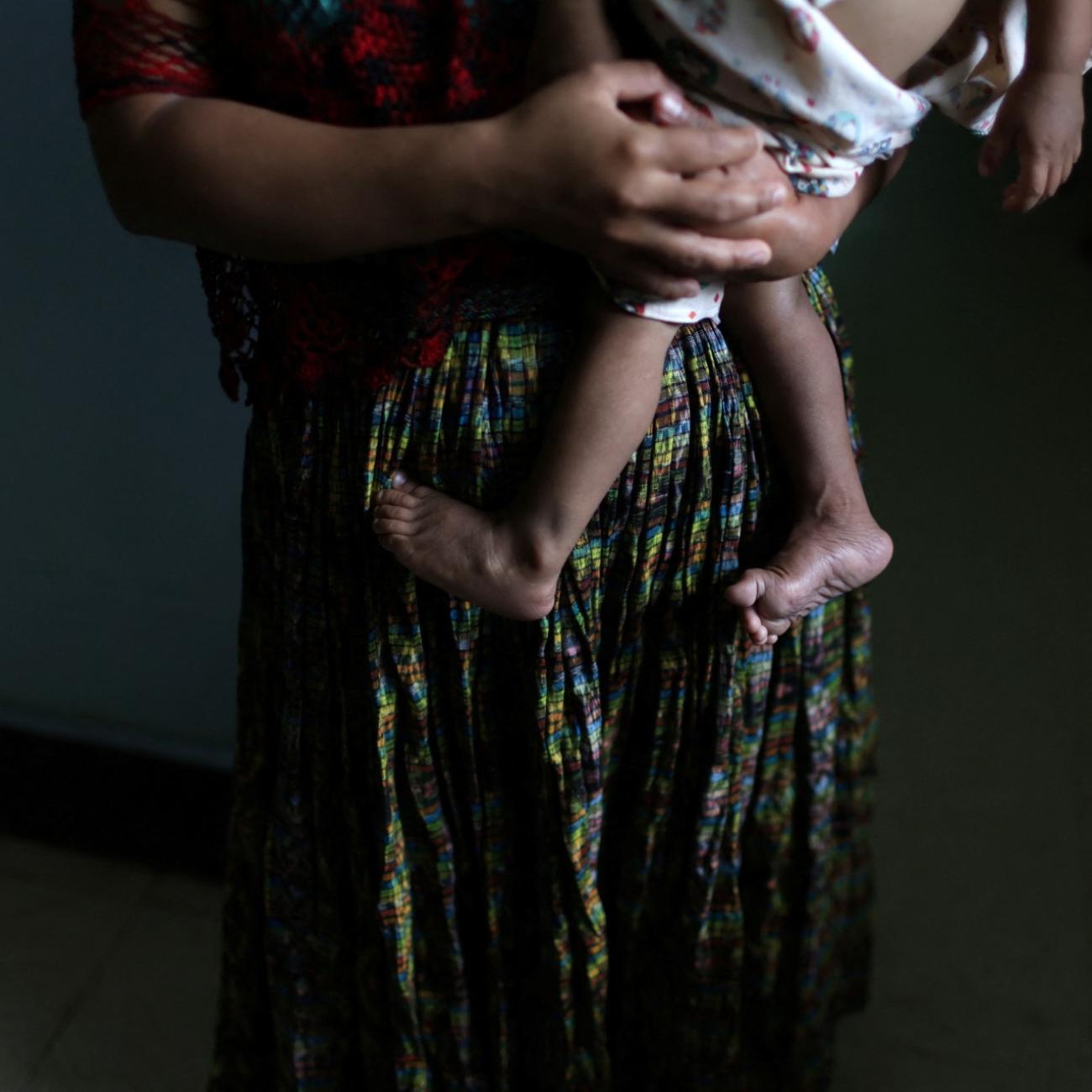 A woman holds her holds her one-year-old son at the Maternal and Child Care Center. 