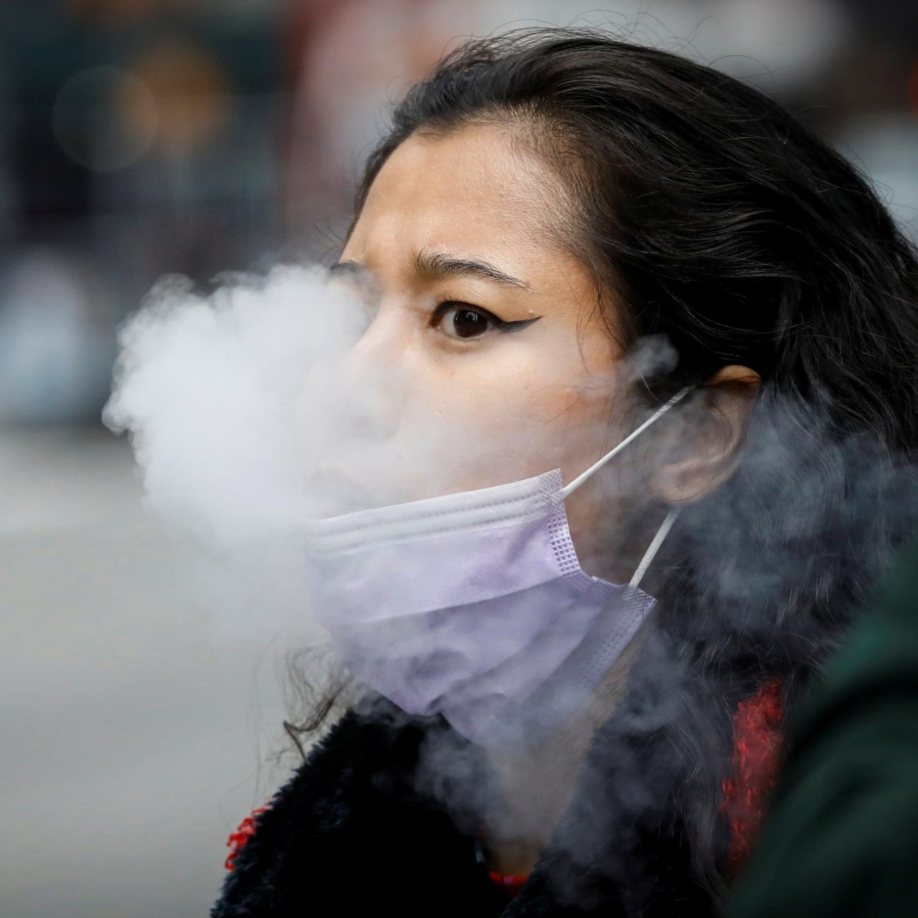 A woman exhales after vaping in Times Square, during the coronavirus disease (COVID-19) outbreak, in New York City, U.S., March 31, 2020. 