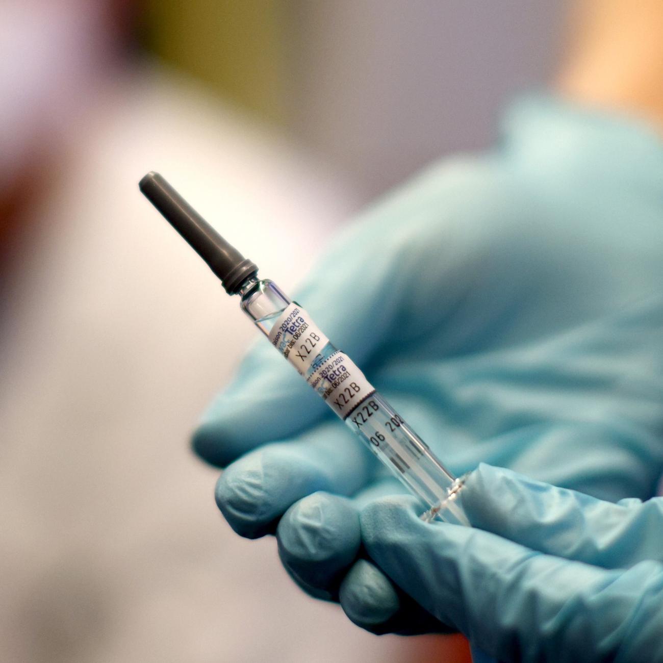 A healthcare worker of the free influenza vaccination program holds a flu vaccine.