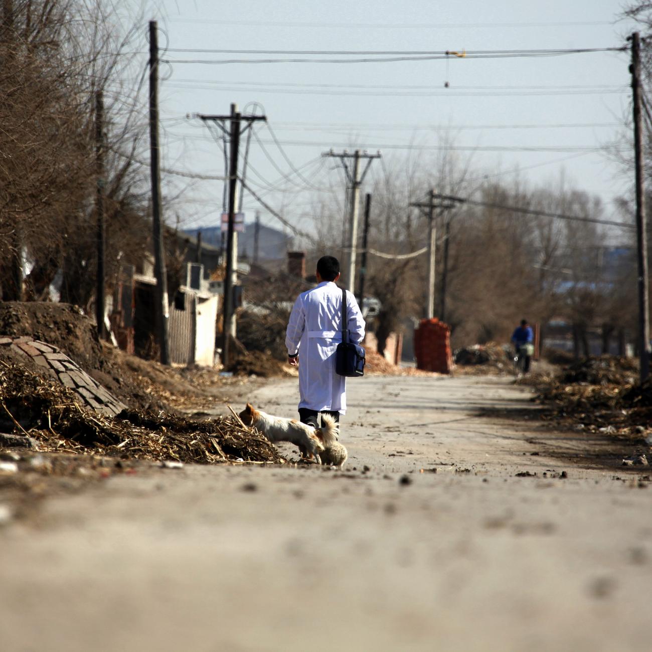 Doctor Li Tongqiang walks along a road through the village of Jianhua.