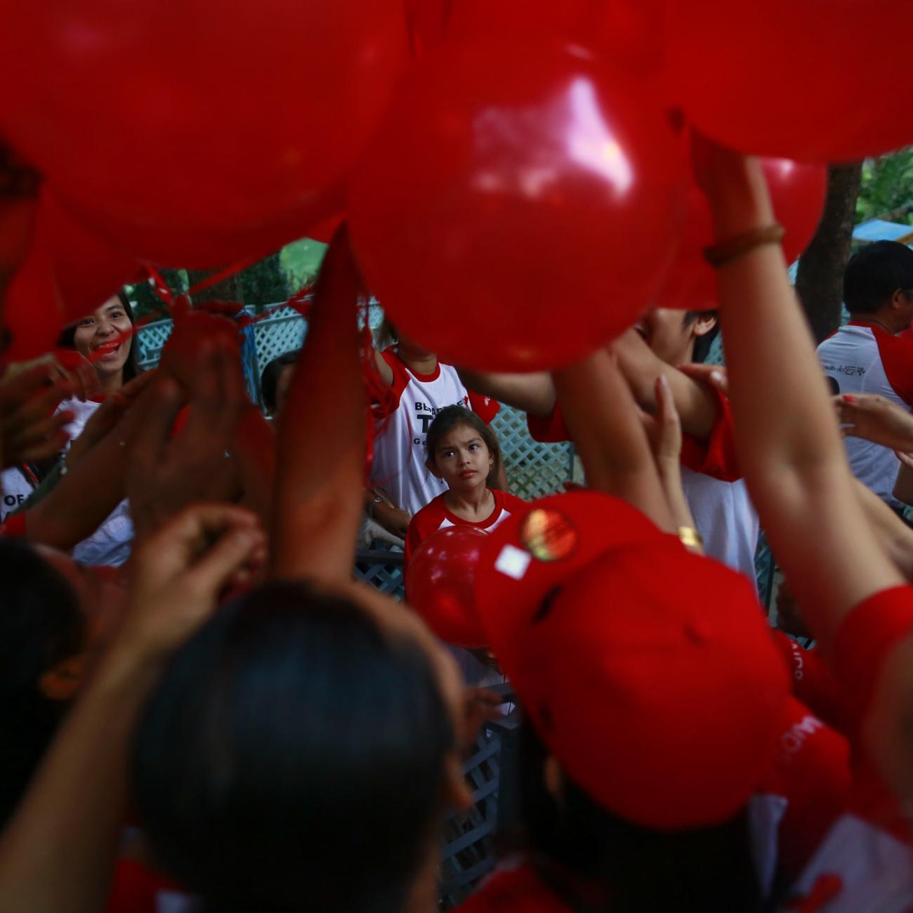 People take balloons before a march ahead of World AIDS Day 2013 at Kandawgyi garden in Yangon November 30, 2013. About one thousand people, including HIV/Aids patients, attended the event.