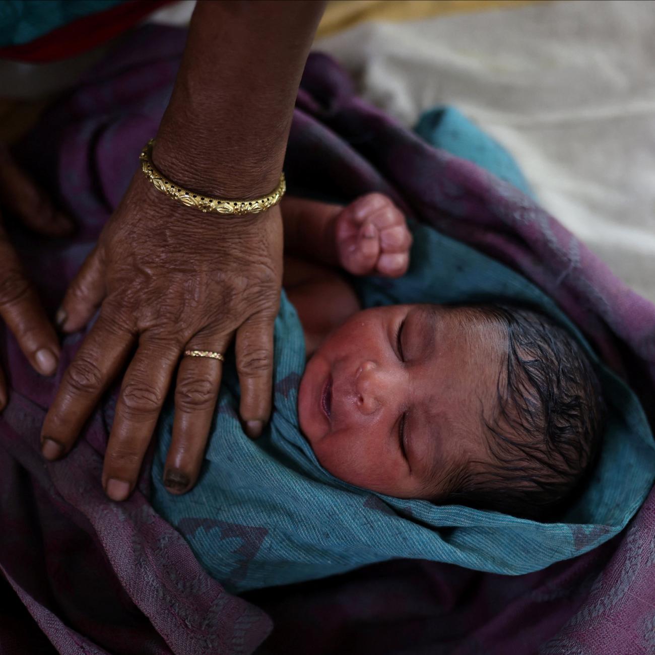 A nurse takes care of a newborn baby after the birth at a hospital in Kishanganj district, Bihar, India, March 20, 2023. India's fertility rate, fell to 2.0 in 2019-2021, but state health officials estimate Kishanganj's fertility rate at 4.8 or 4.9, creating population growth that the state is trying to curb with the distribution of condoms and birth control pills. REUTERS/Anushree Fadnavis