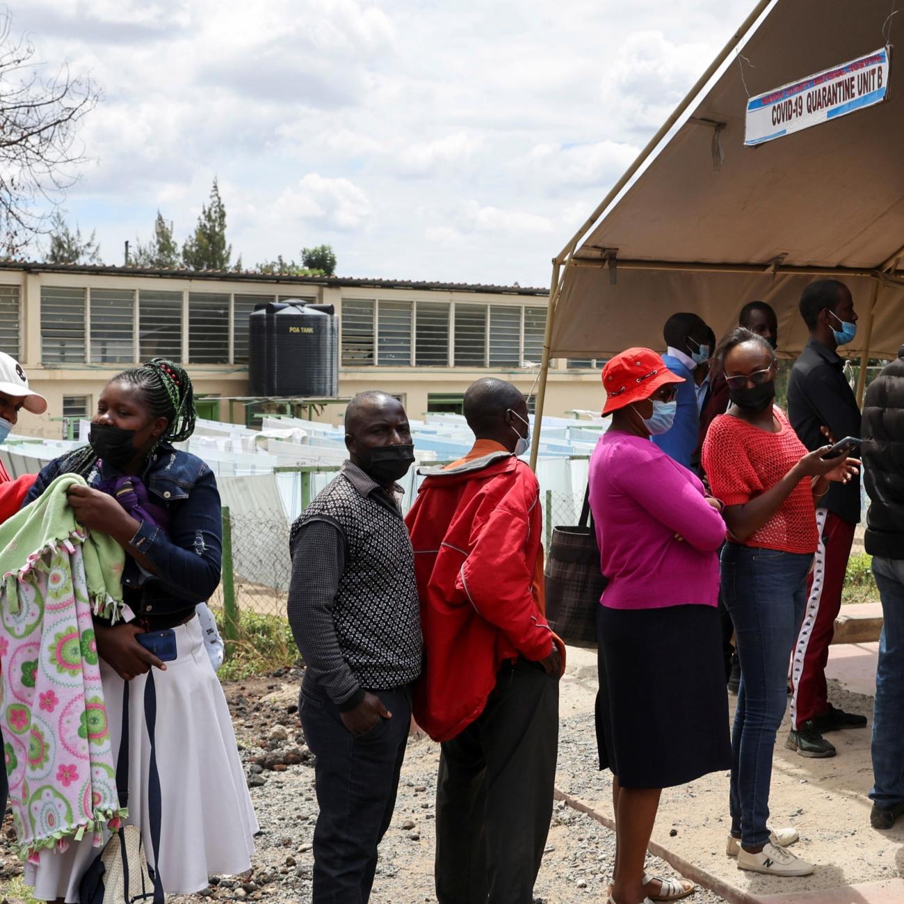 People stand in line to receive a COVID-19 vaccine, at the Narok County Referral Hospital.