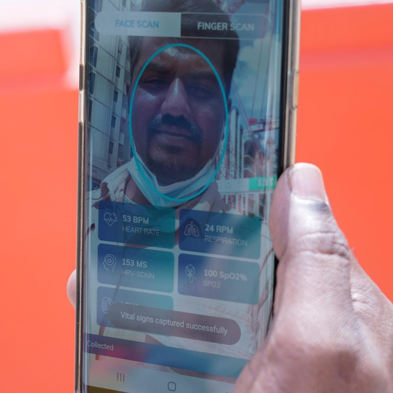 Gunasekar Udayakumar uses the Nervotec app to scan his face and check his vital signs as part of a daily checkup for employees, at a construction site, in central Singapore, on February 19 2021.