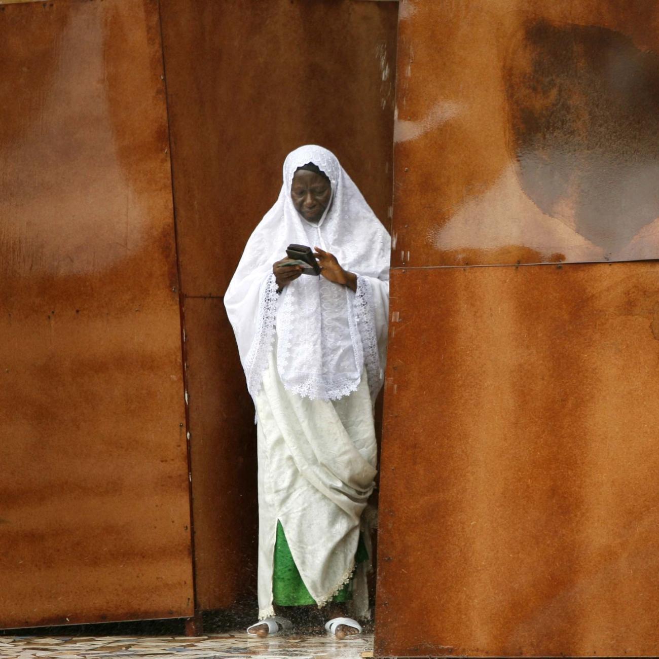 A Gambian woman puts her identity card back into her purse while exiting a polling station, in Serekunda, Gambia, on September 22, 2006.