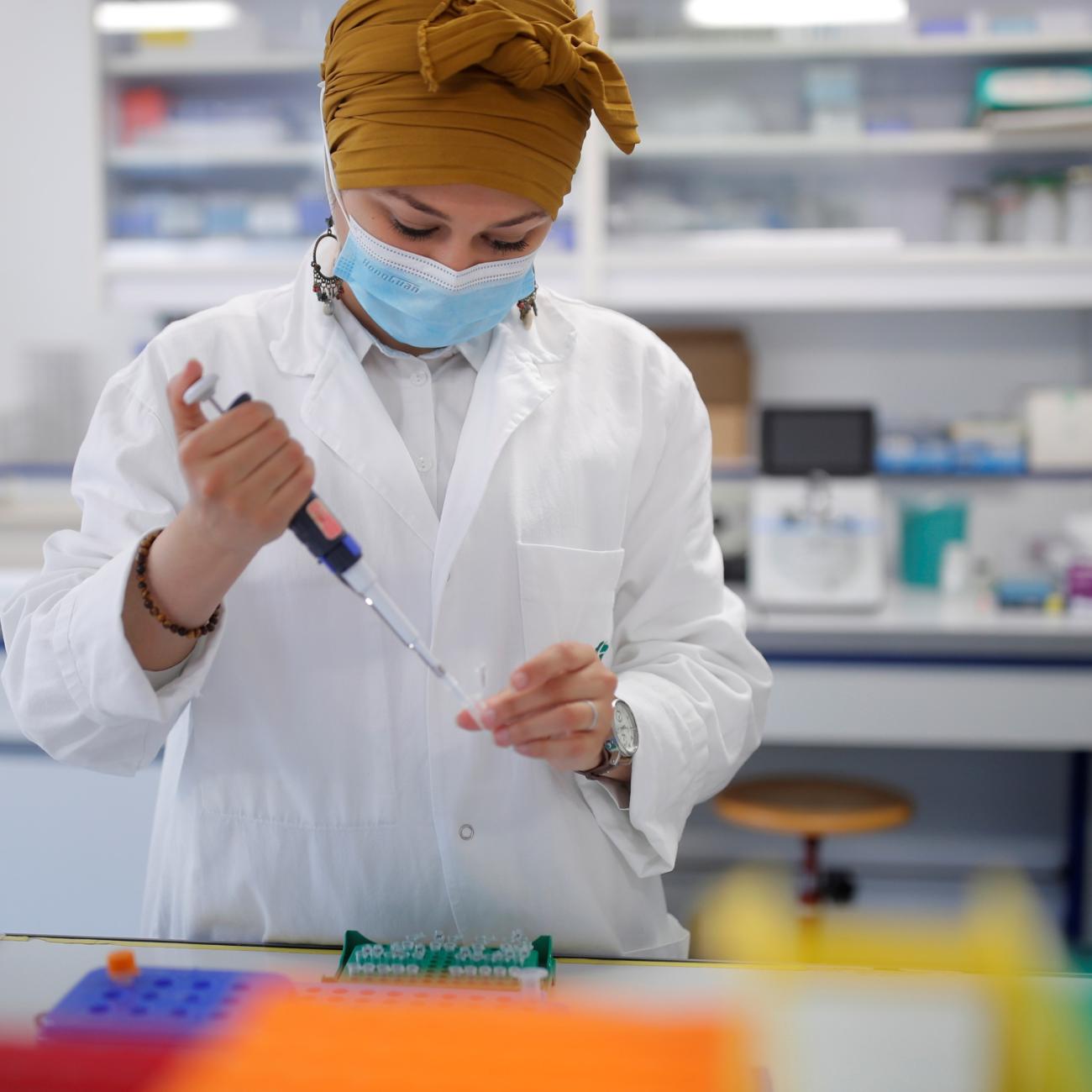 A researcher manipulates proteins in a laboratory as part of a project to develop a COVID nasal spray vaccine.