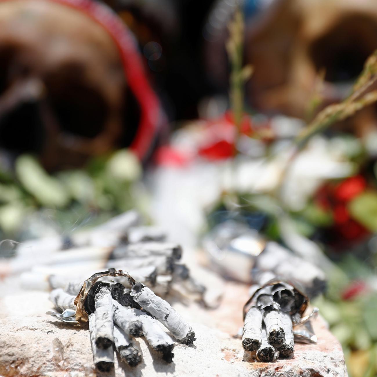 Cigarette butts are seen in front of exhibited skulls during the Day of Skulls celebrations in La Paz, Bolivia November 8, 2019. The photo shows two human skulls laid out with flowers in a ceremonial way with a number of burned cigarettes in the foreground. REUTERS/Kai Pfaffenbach