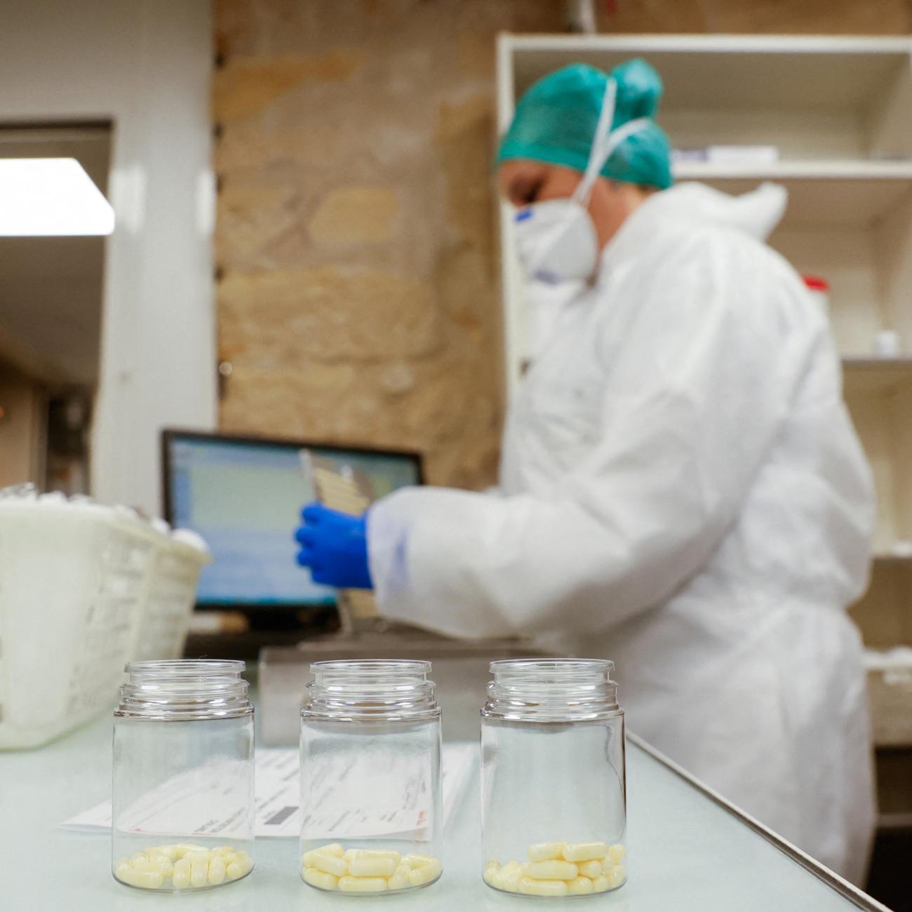 A person works packaging capsules of amoxicillin at the Delpech pharmacy.