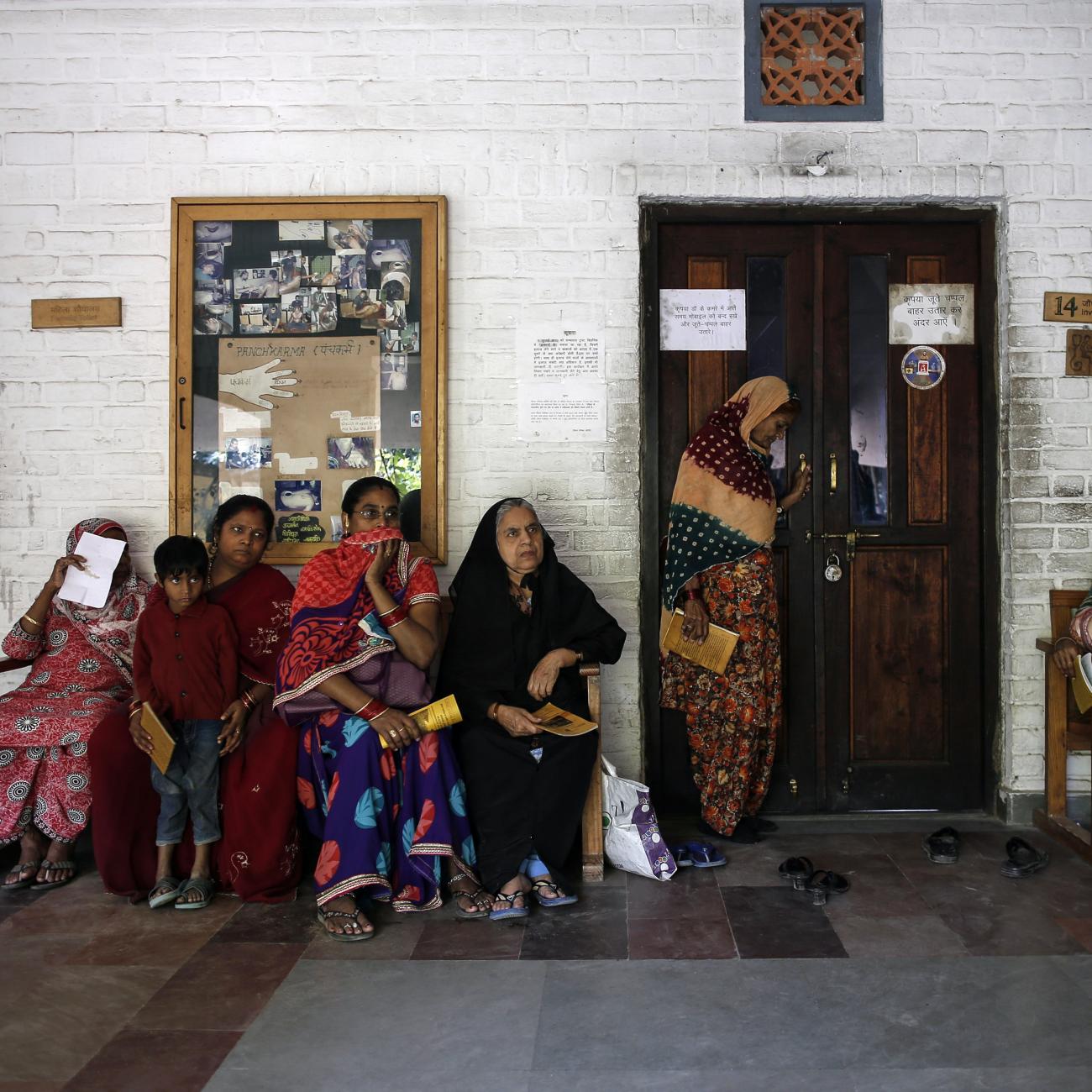 People wait to receive medicine at a clinic.